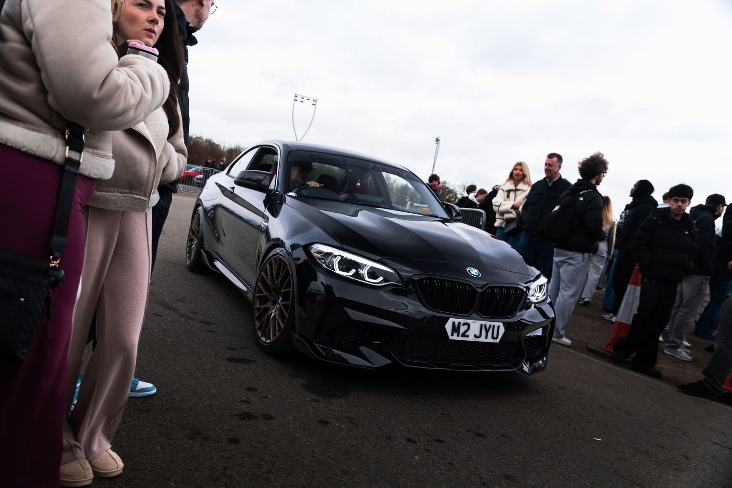 Dark BMW M2 with wide body kit and W2JYU number plate at a UK car meet.