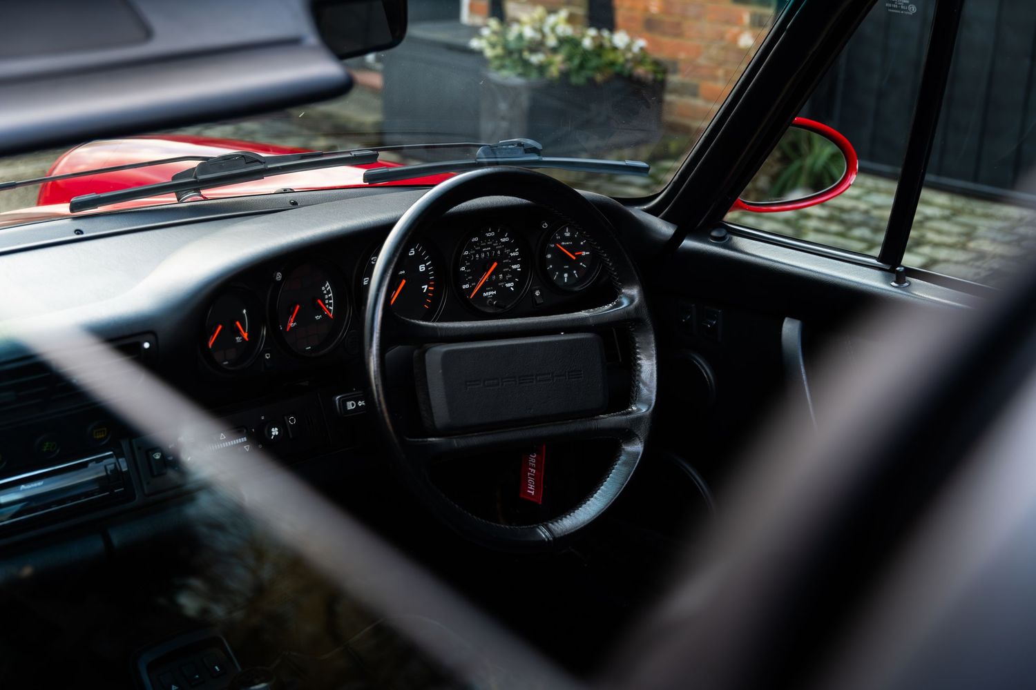 Interior view of a Porsche 911 showing the classic dashboard, instrument cluster, and steering wheel.