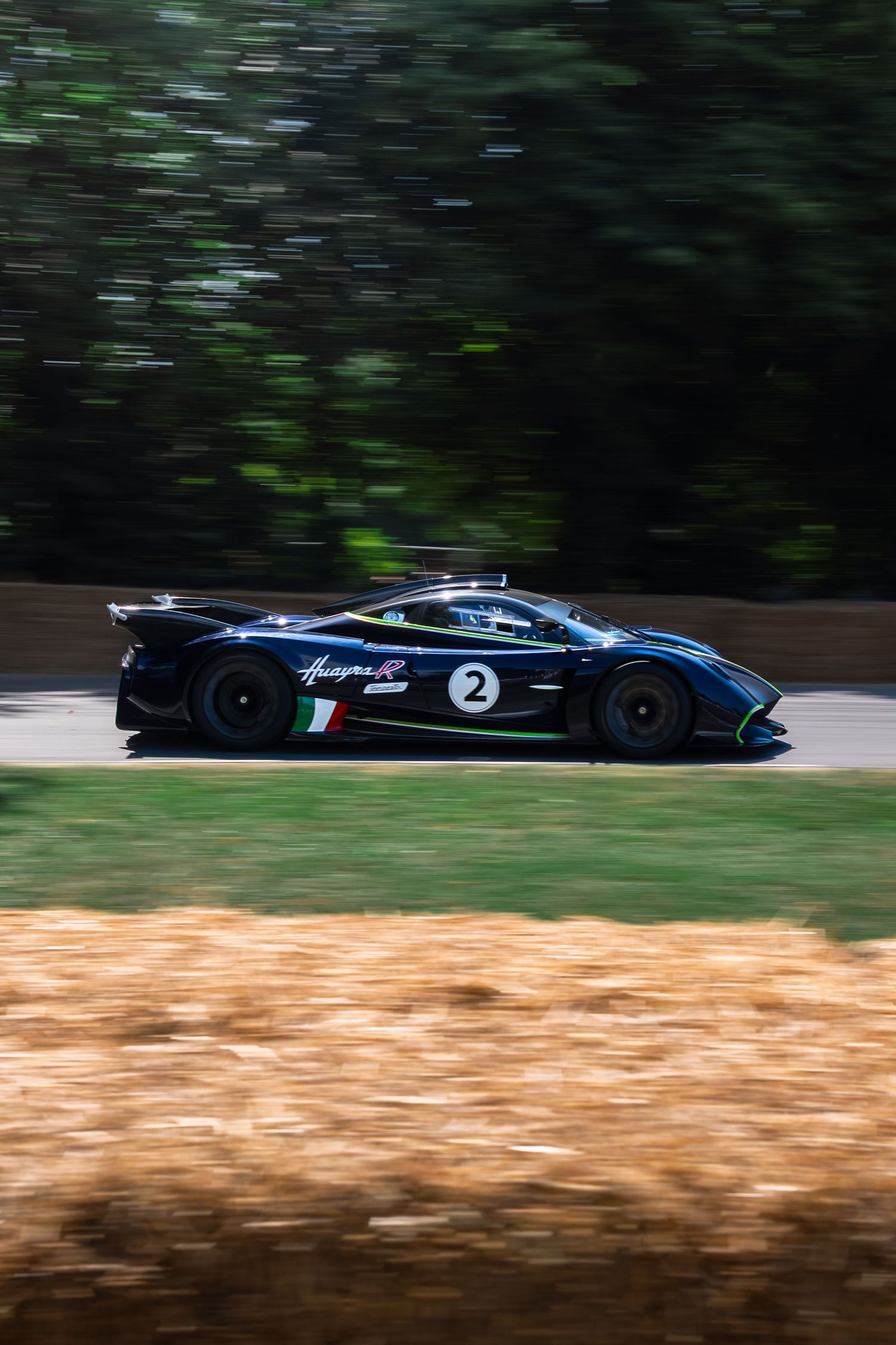 Black Pagani Huayra R race car number 2 speeding on track with motion blur background at Goodwood Festival of Speed.