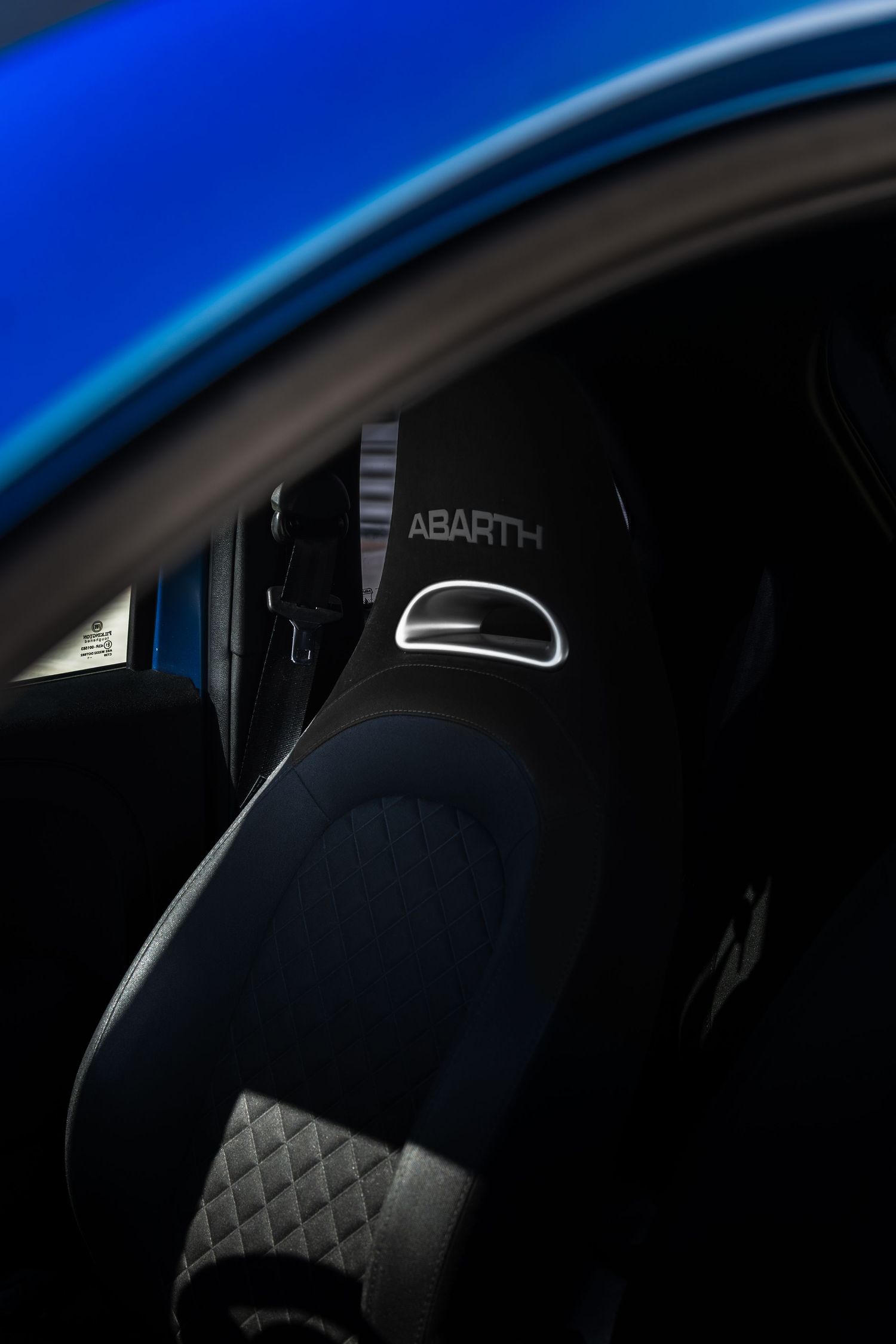 Abarth-branded sport seat interior detail shot inside a blue Abarth 500.