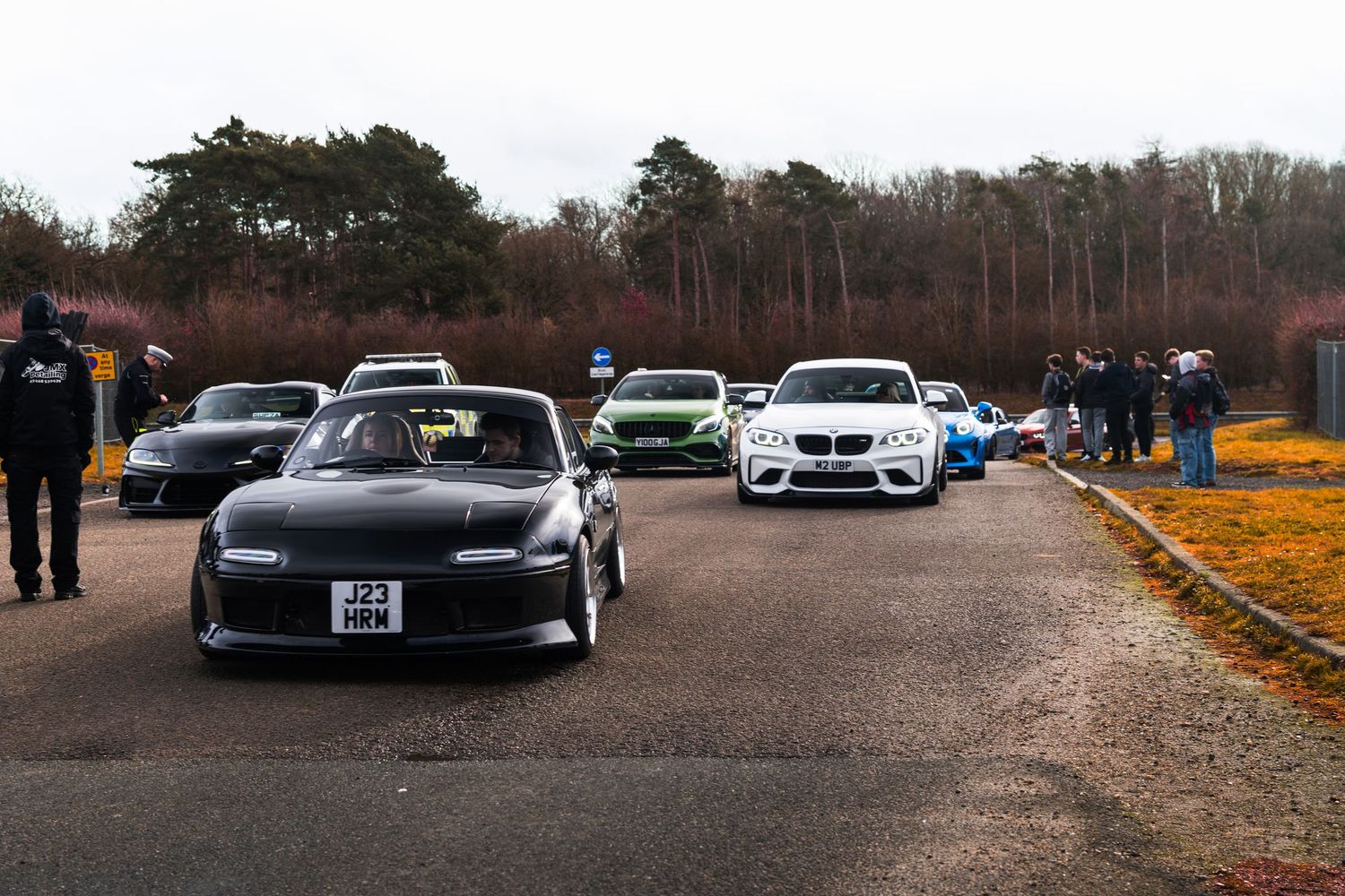 A lineup of modified cars including a black Nissan Silvia at an outdoor car meet event.