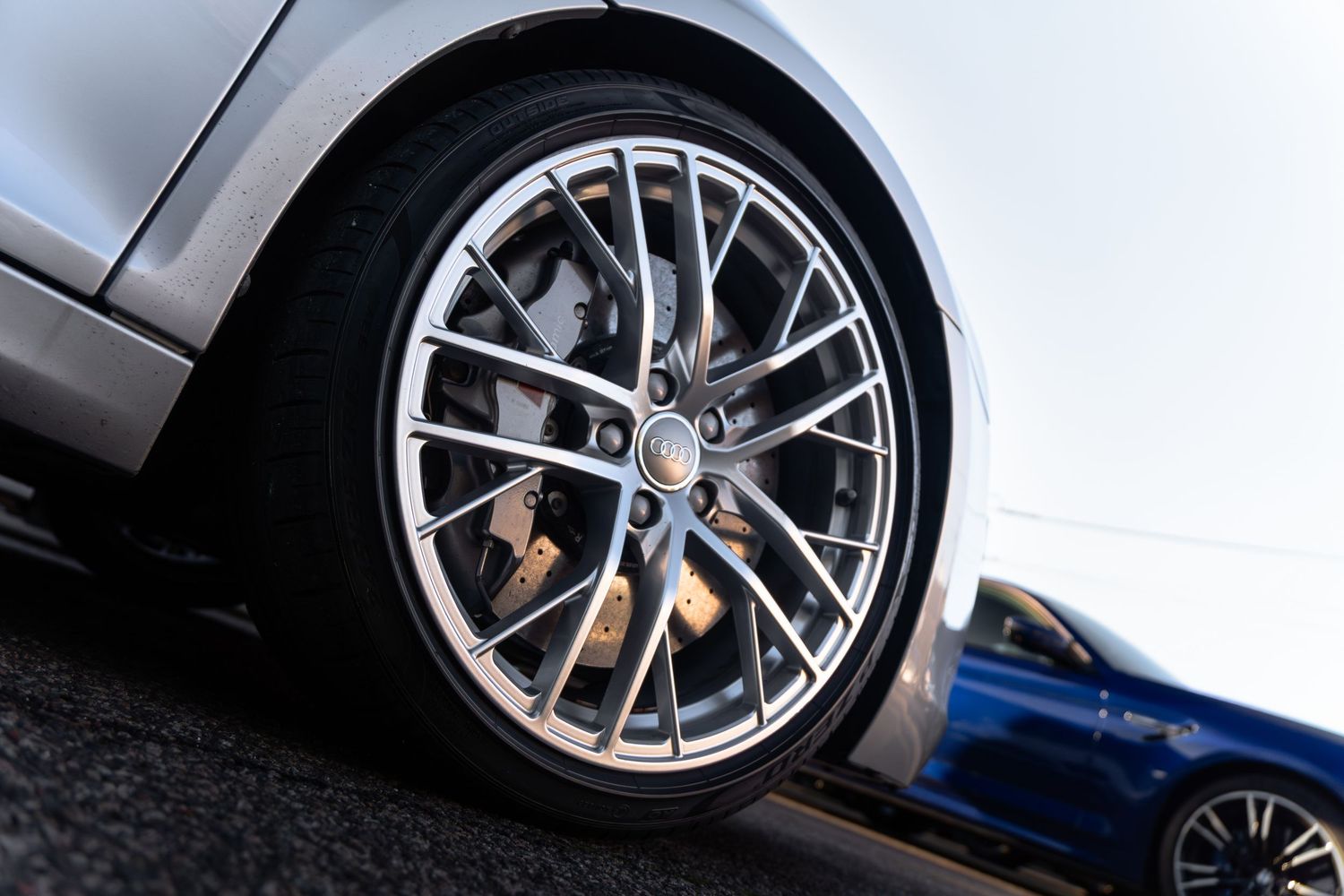 Close-up of a chrome multi-spoke alloy wheel with large brake caliper on a silver sports car.