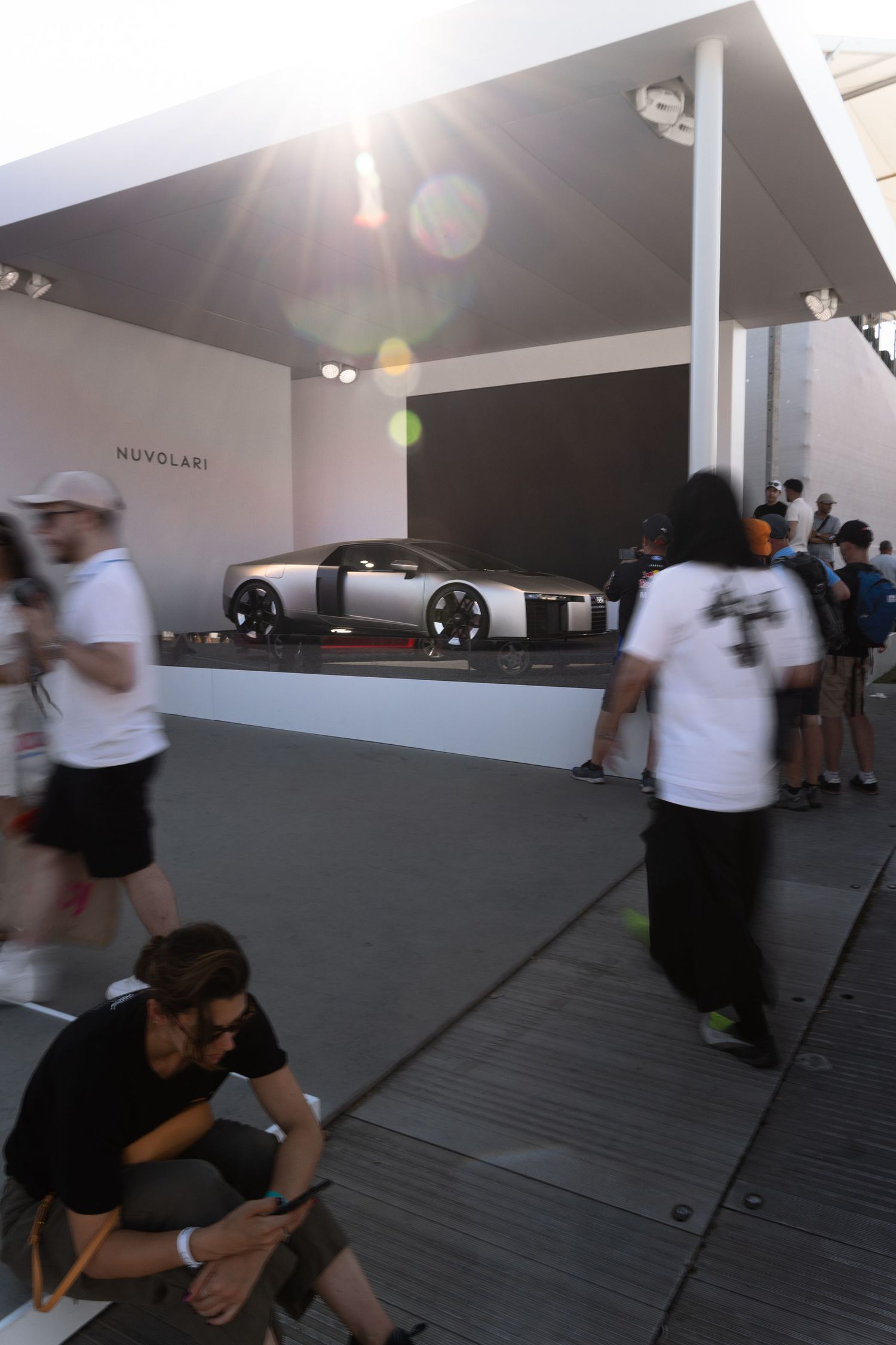 Nuvolari concept car on display at an outdoor automotive exhibition with visitors walking past under a canopy.