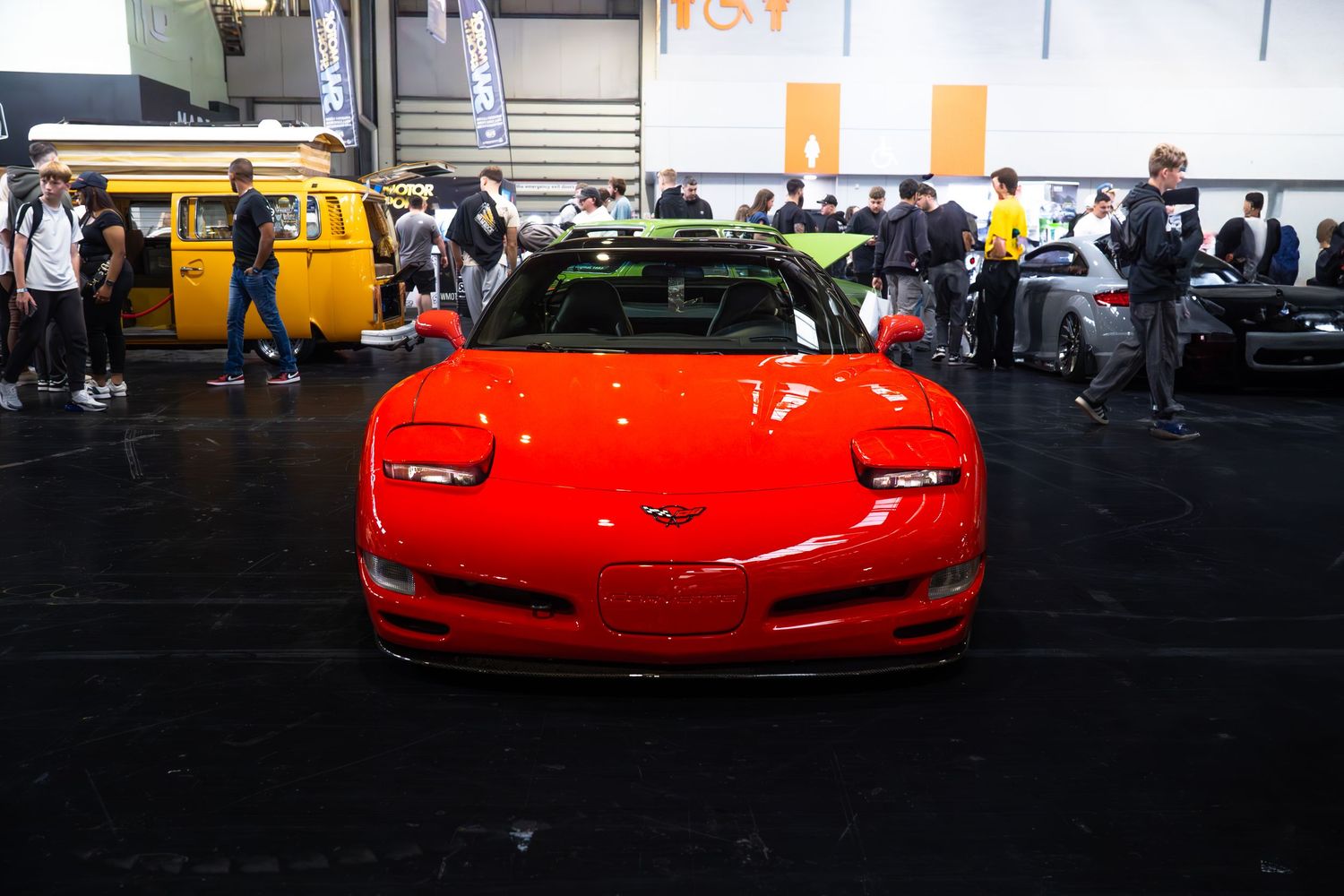 Red Chevrolet Corvette C5 on display at an indoor automotive exhibition.