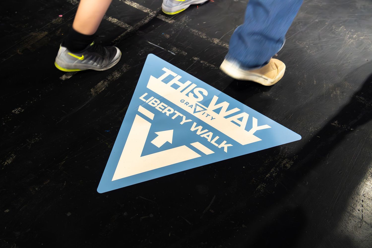 Liberty Walk branded directional floor sign at an indoor car show event.