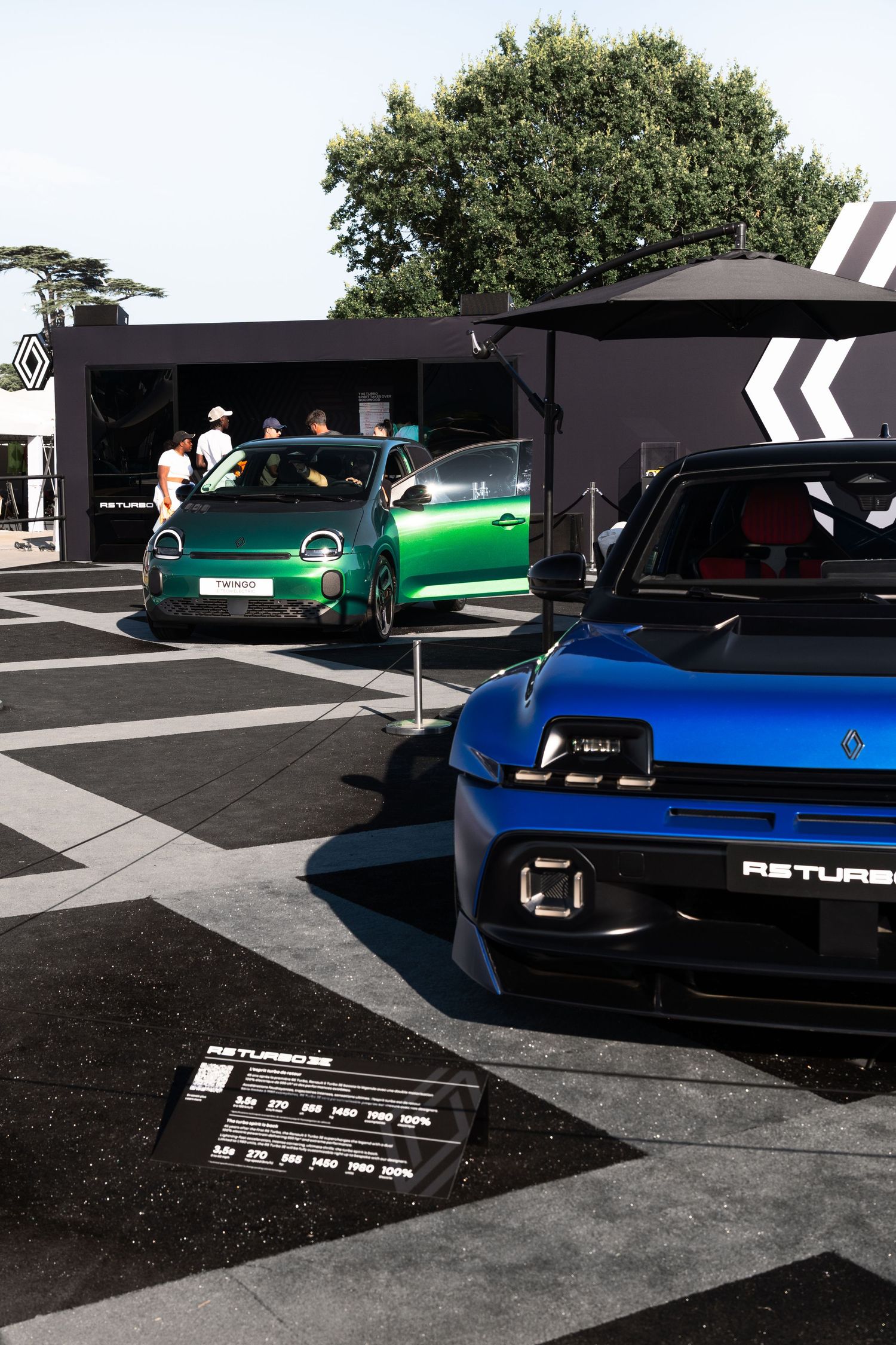 Renault R5 Turbo concept cars in blue and green on display at an outdoor automotive exhibition event.