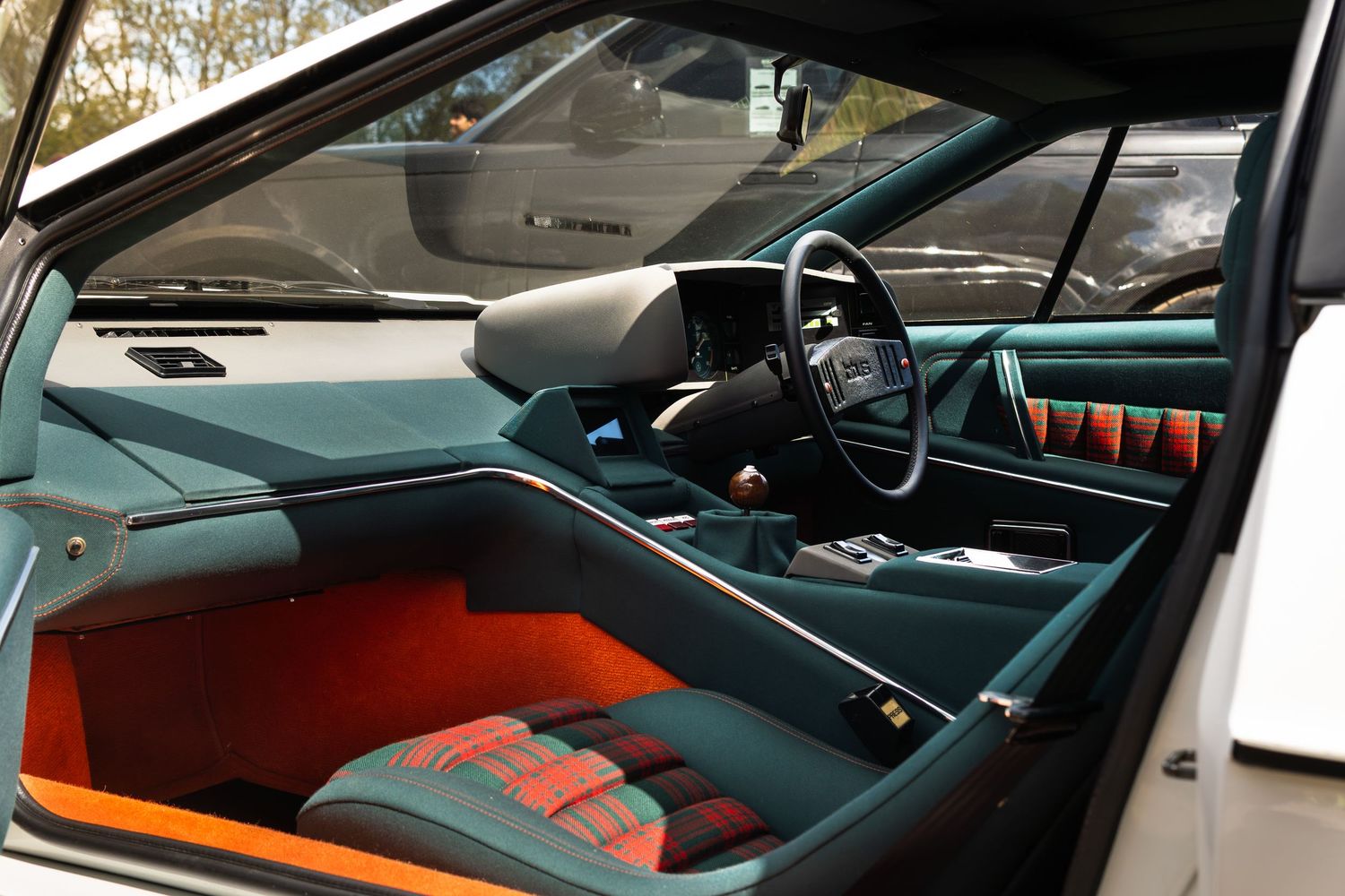 Classic concept car interior with teal and orange color scheme, plaid seats, and right-hand drive configuration.