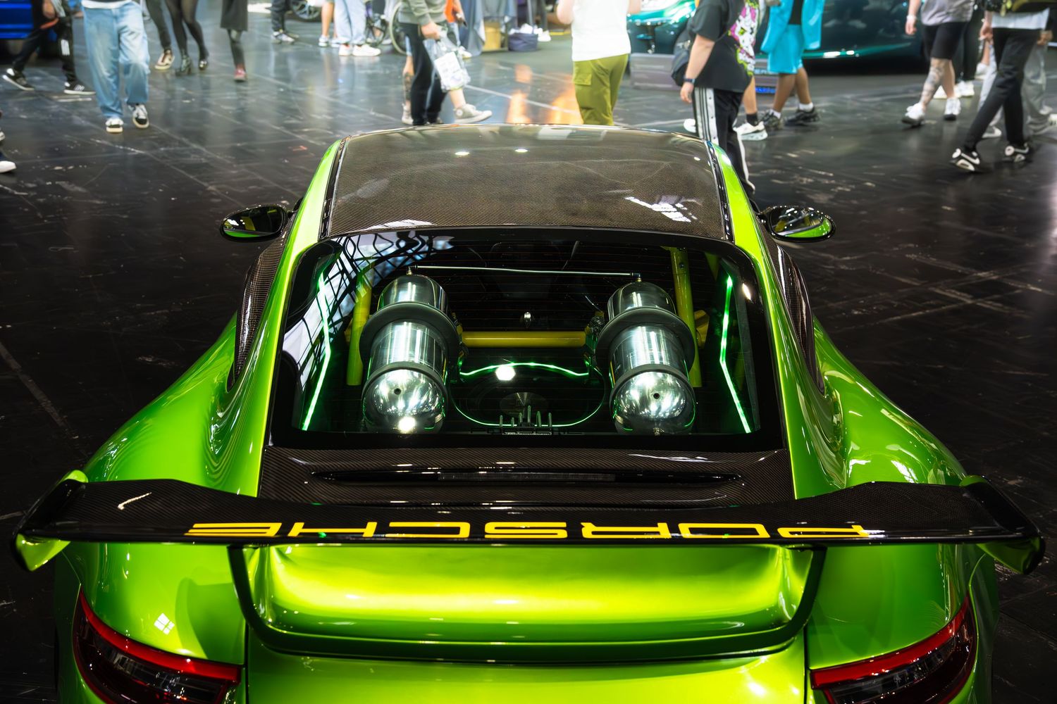 Top-down view of a lime green Porsche 911 GT3 RS with exposed twin-turbocharged flat-six engine.