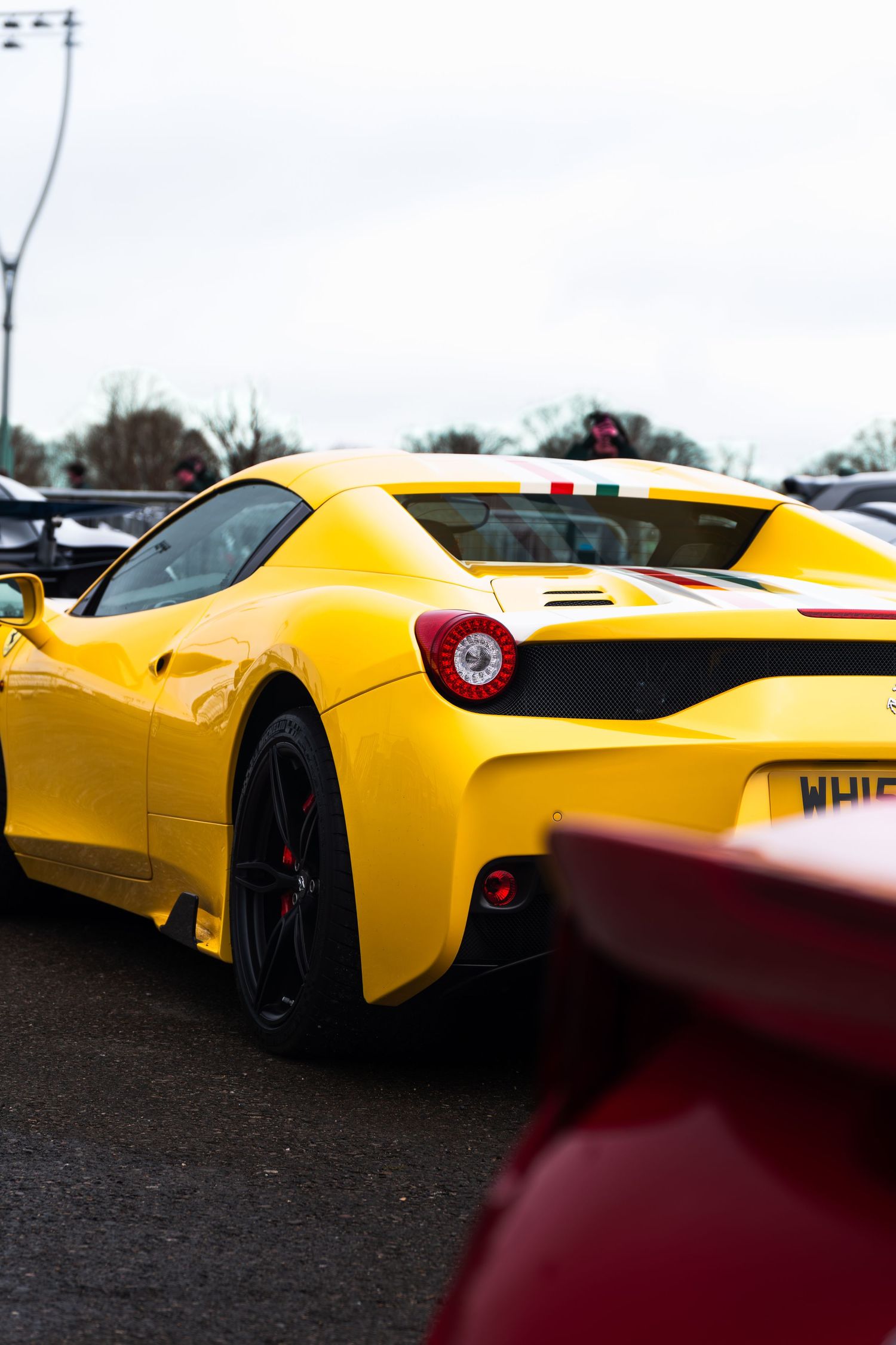 Yellow Ferrari 458 Speciale with Italian flag detail at a UK car meet.
