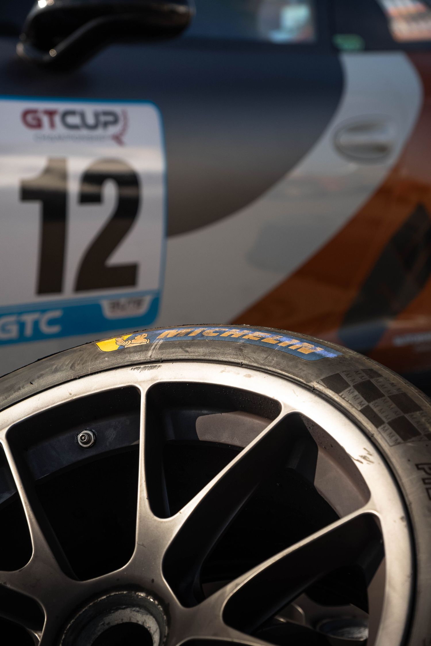 Michelin racing tire on a GT Cup car number 12 in the GTC class at a motorsport event.