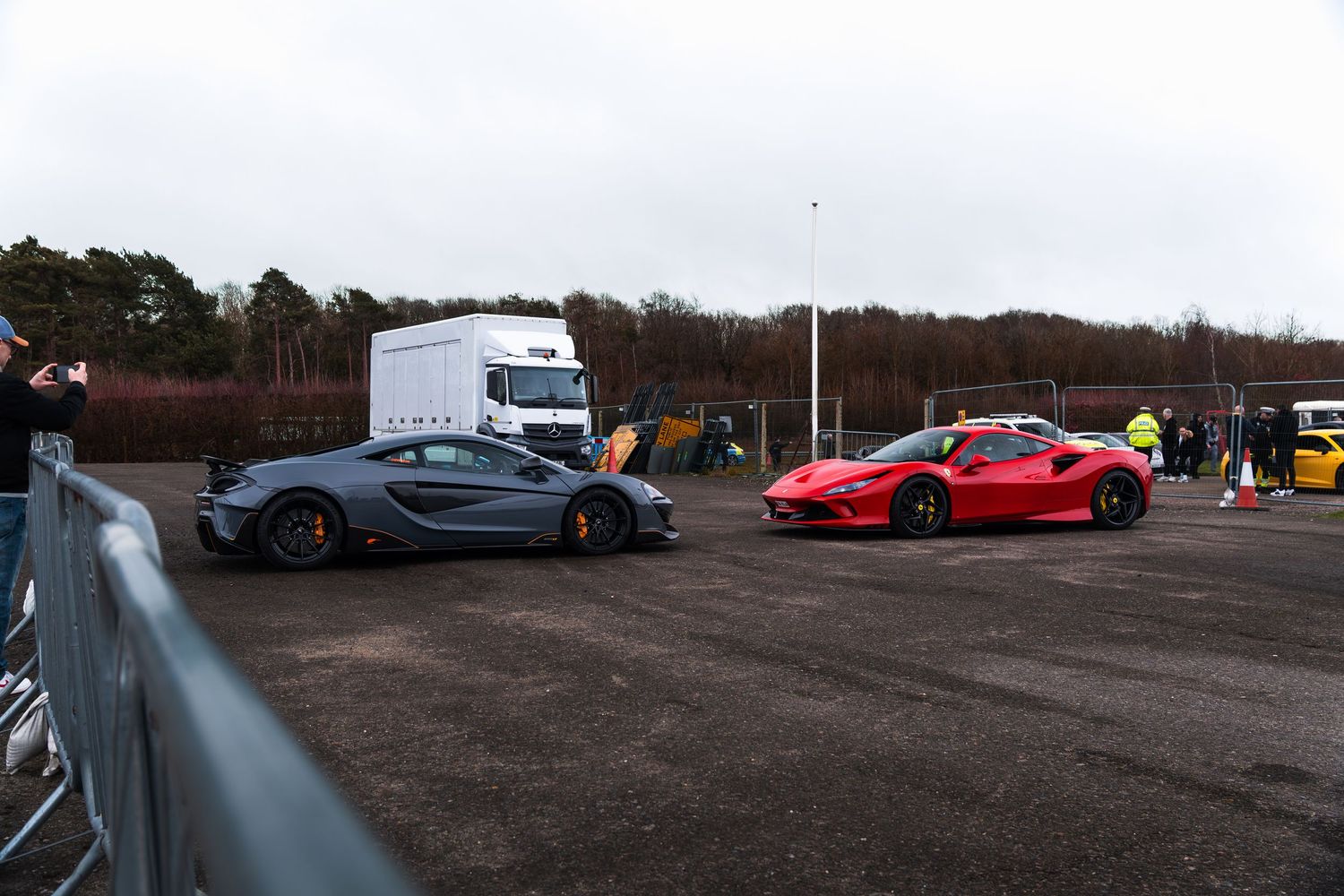 Gray McLaren and red Ferrari F8 Tributo at a UK supercar drag event.