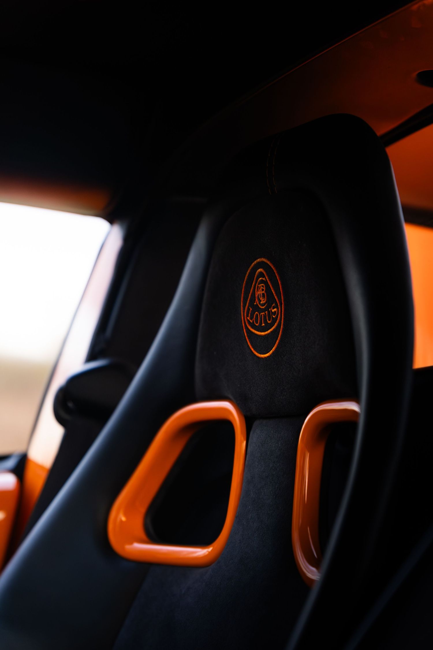 Black and orange Lotus Elise sport seat with embroidered Lotus logo.