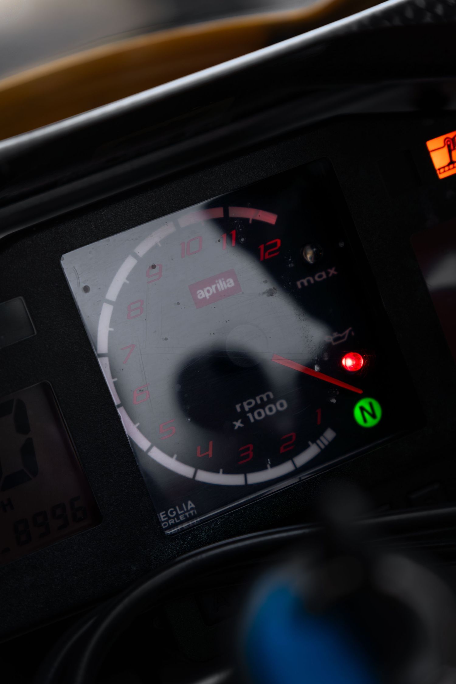 Aprilia motorcycle dashboard showing tachometer with RPM gauge and neutral indicator light.