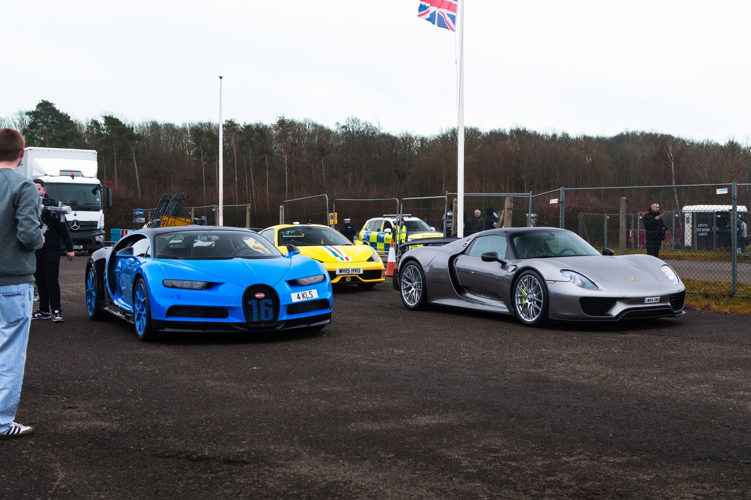Blue Bugatti Chiron and silver Porsche 918 Spyder at outdoor supercar event.