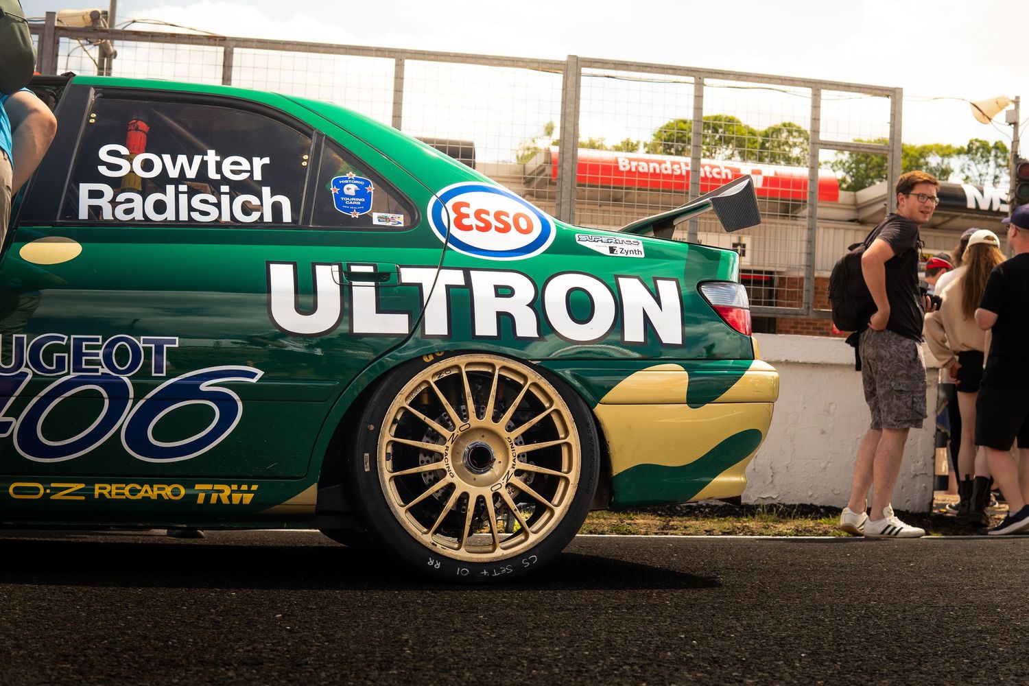 Green and gold Peugeot 406 BTCC race car with Ultron and Esso sponsorship on display at event.