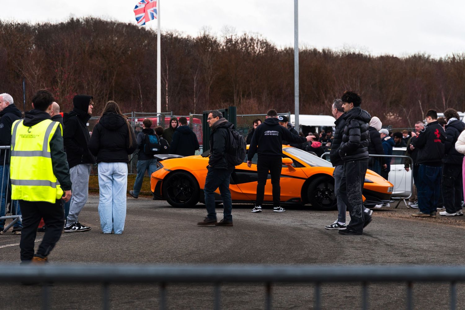 Orange Lamborghini supercar displayed at a UK car meet with large crowd.
