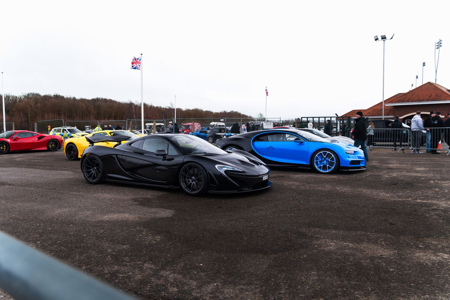 Black McLaren P1 and blue Bugatti Chiron at a UK supercar meet event.