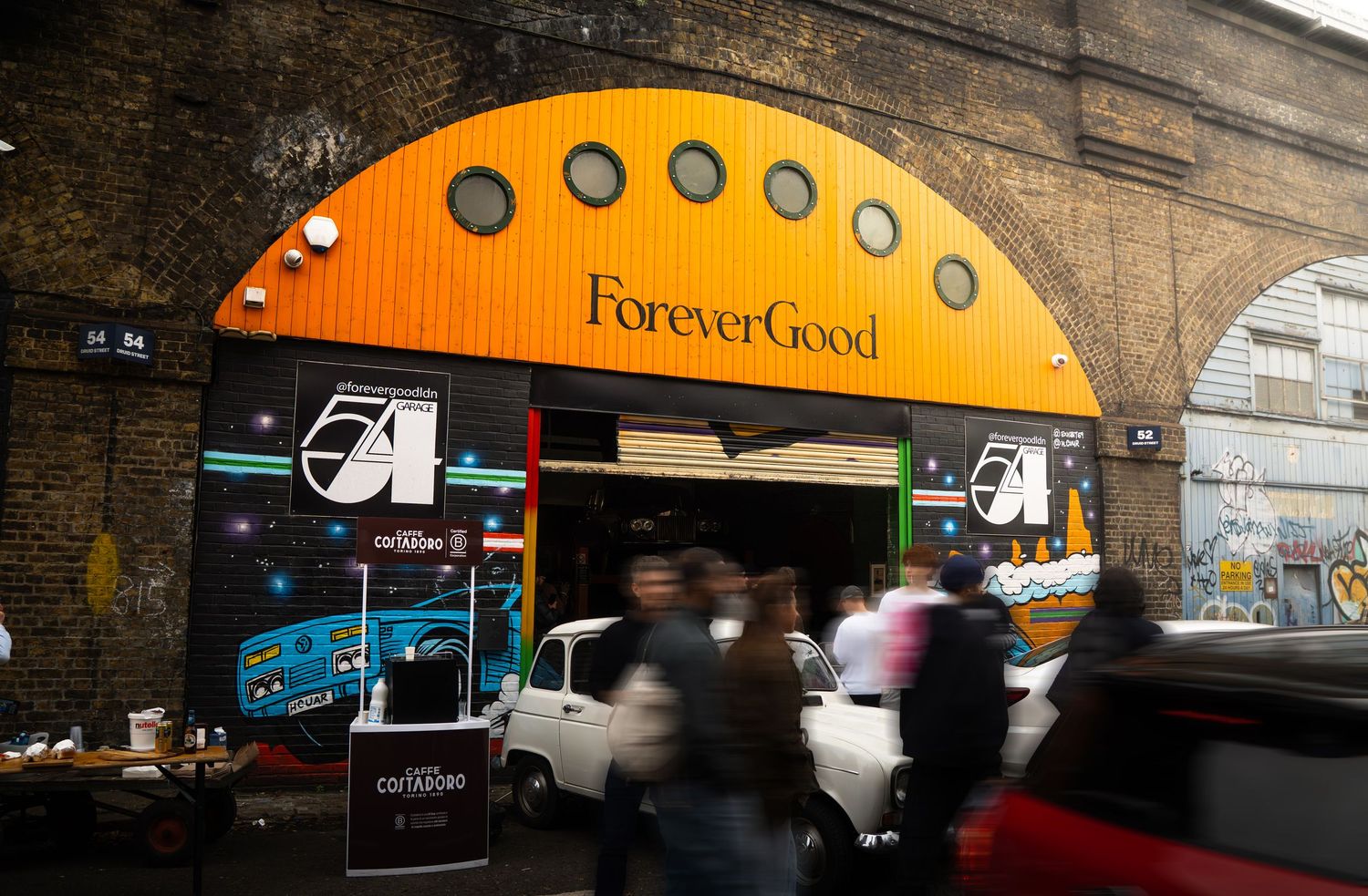 ForeverGood yellow arched shopfront with graffiti walls and pedestrians in urban London.
