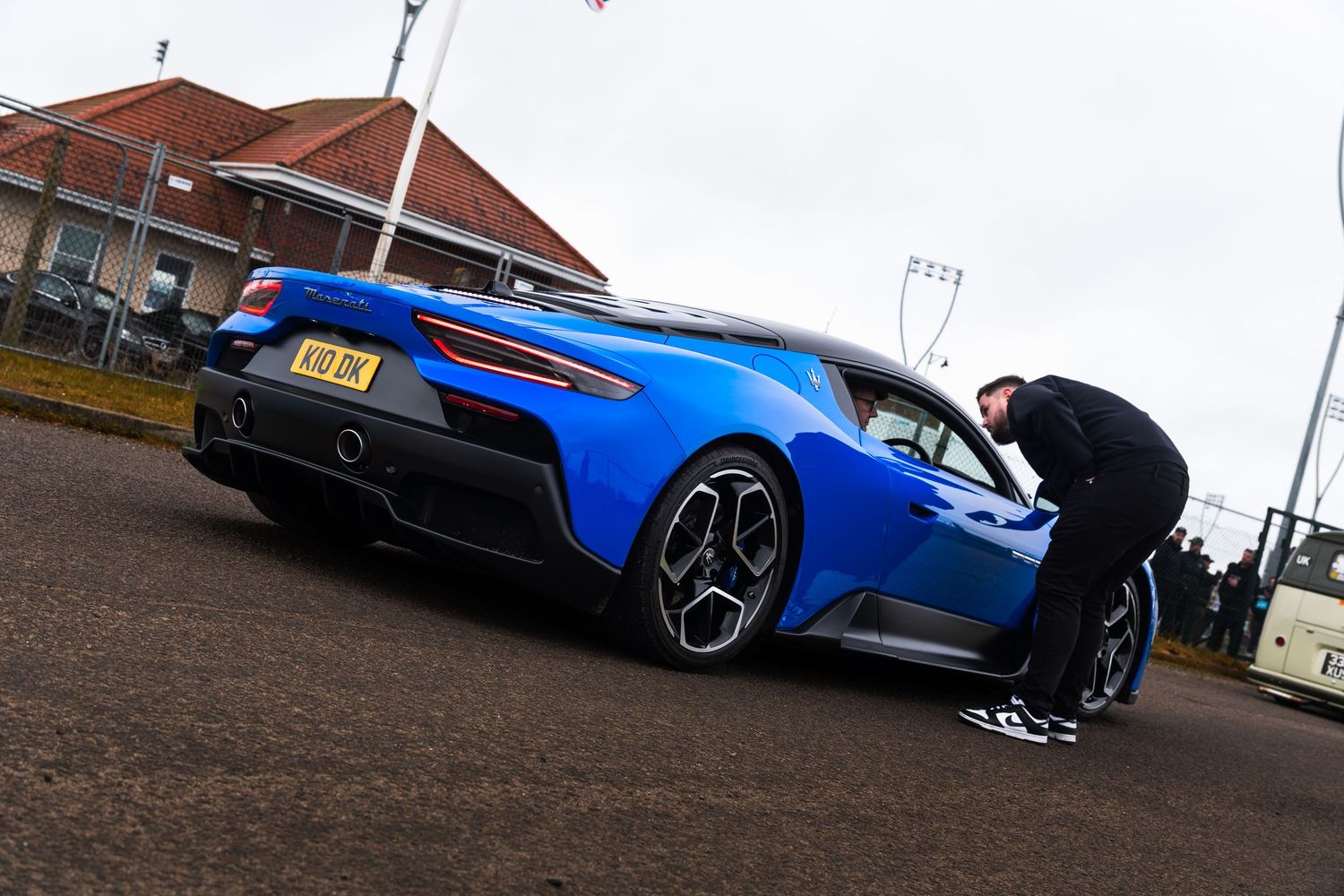 Blue Lamborghini Huracan supercar at a UK car meet with a person leaning against it.