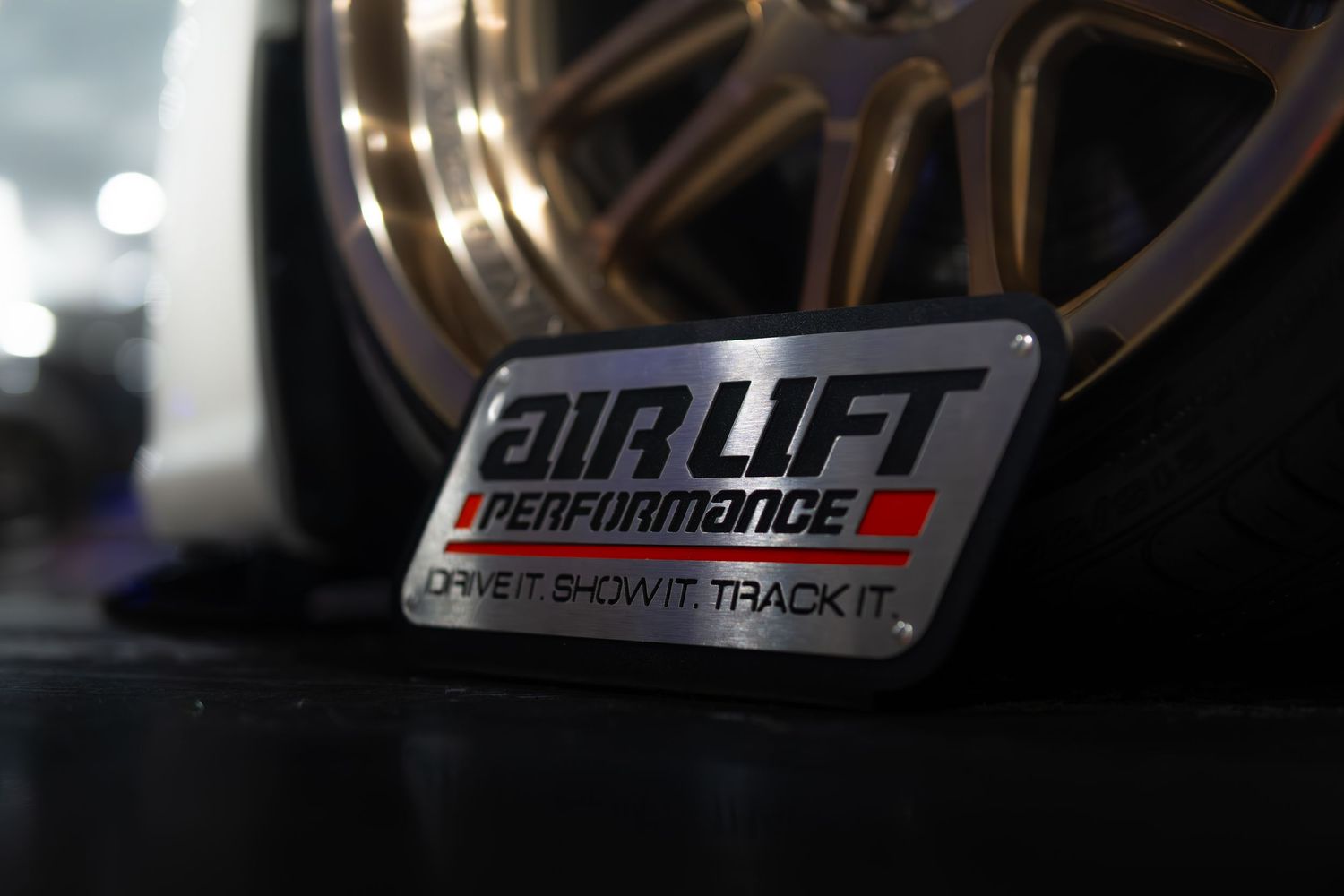 Air Lift Performance badge displayed in front of a bronze multi-spoke alloy wheel.