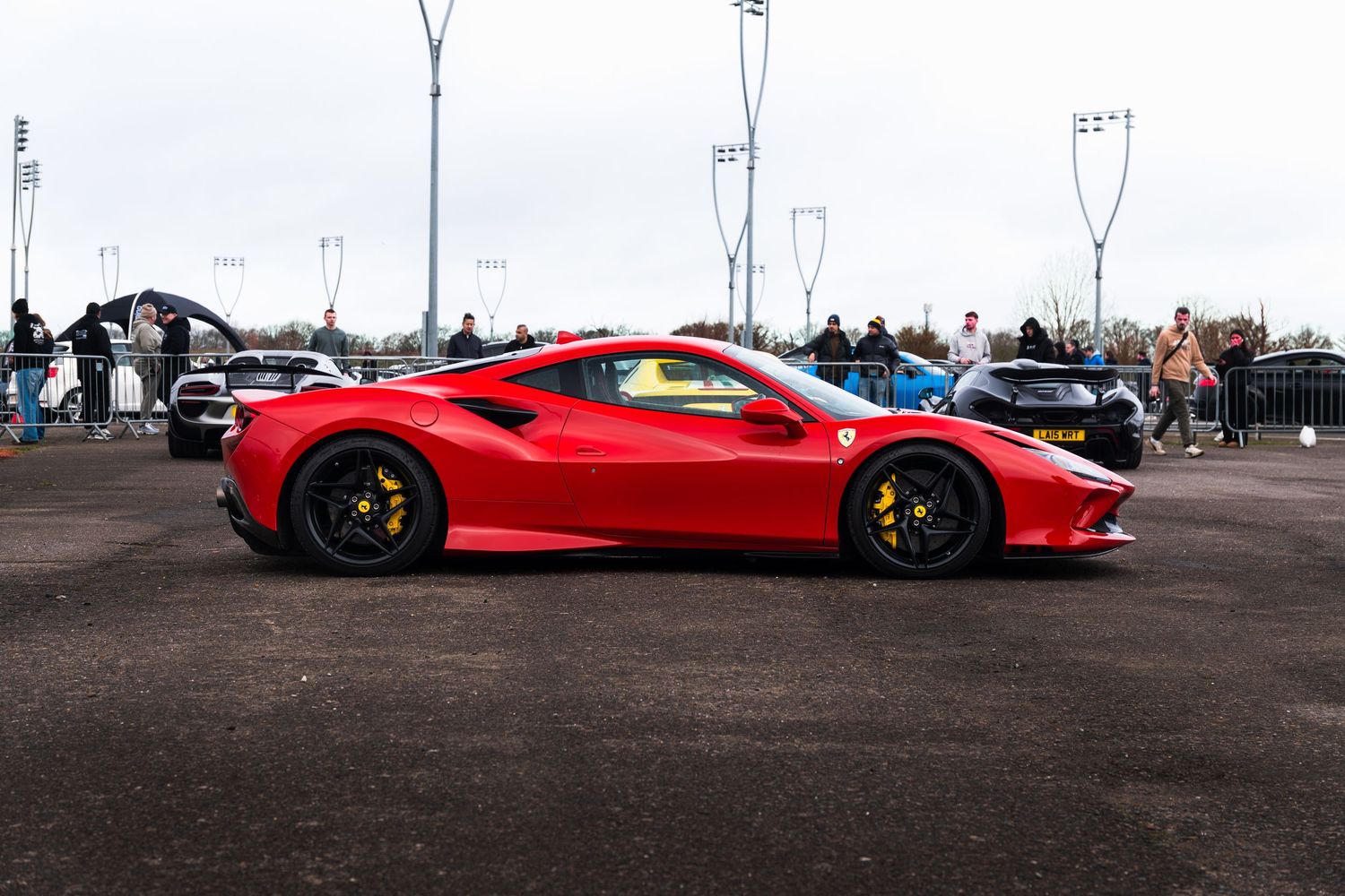 Red Ferrari F8 Tributo supercar parked at a UK car show event.
