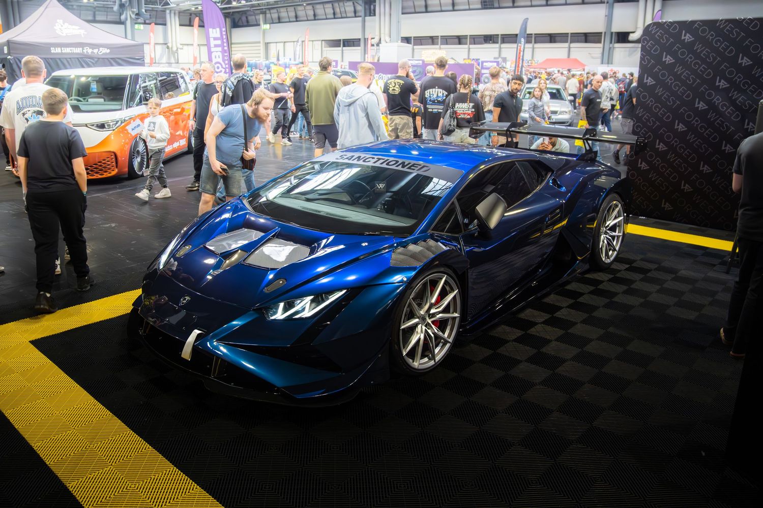 Blue Liberty Walk Lamborghini Huracan on display at an indoor car exhibition.