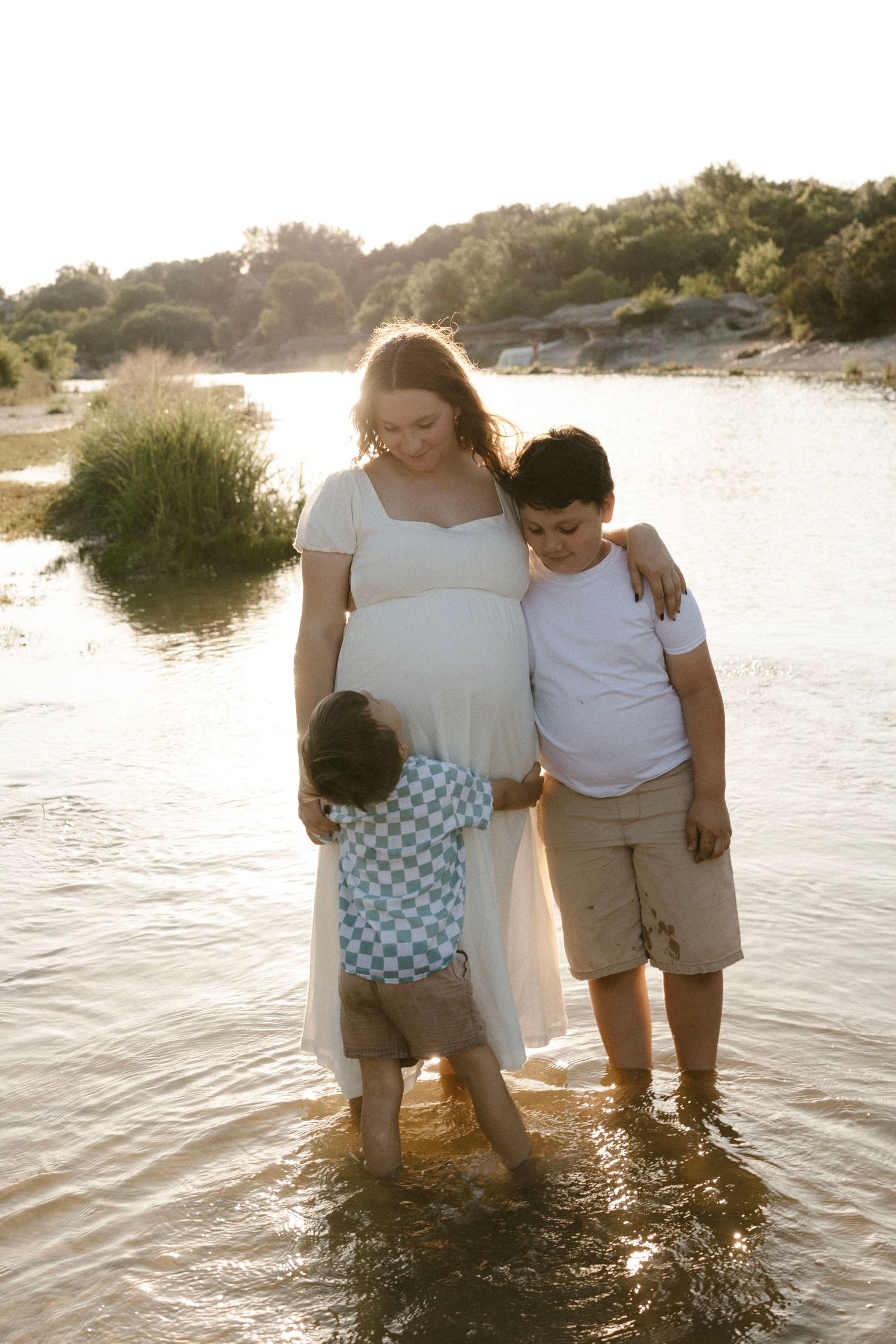 Photographer, Brittany Ruiz, based in Georgetown, TX, & surrounding areas, playing with her kids in shallow water during sunset in a river.