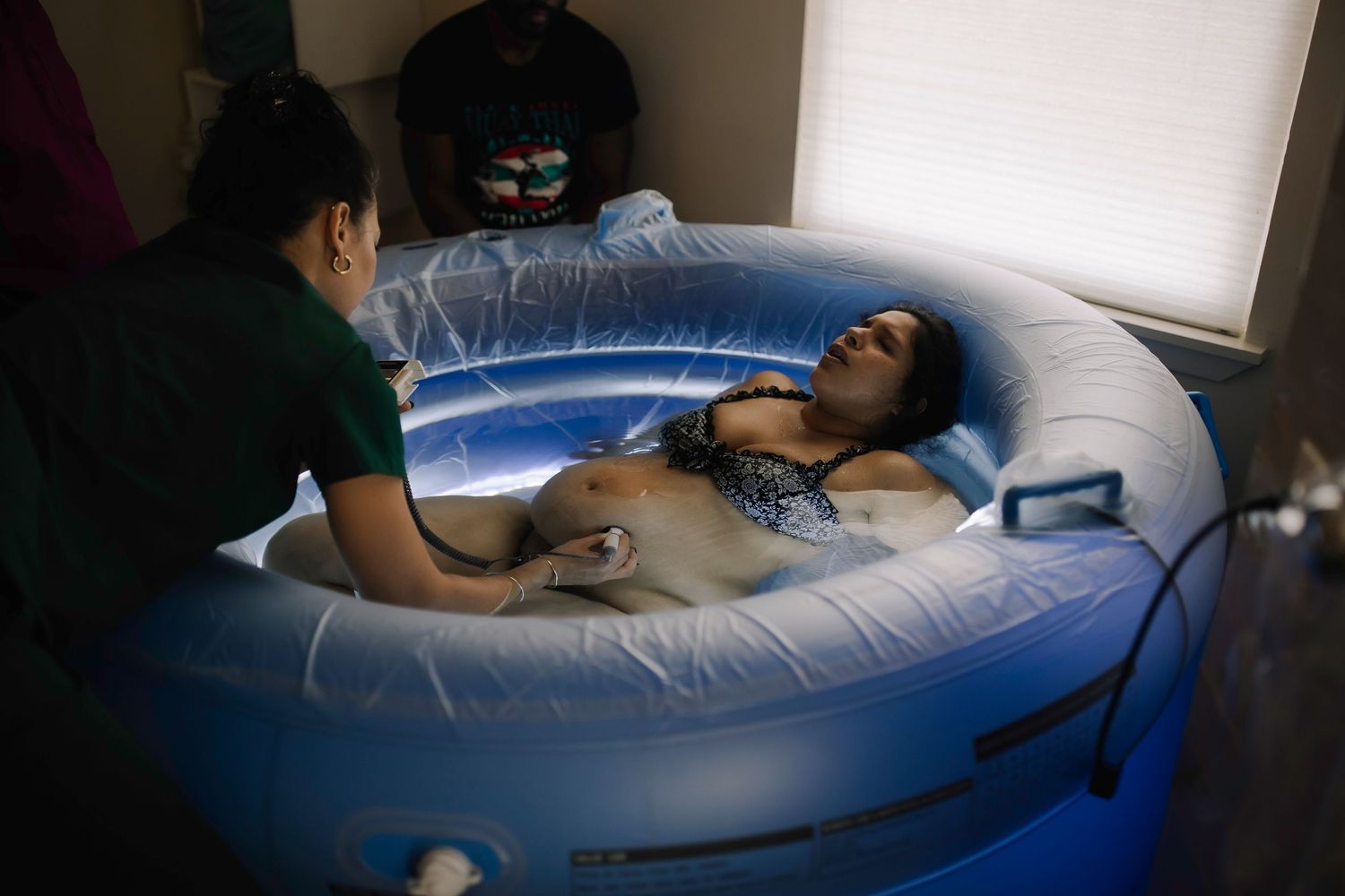 Person relaxing comfortably on a large inflatable blue lounger in a bright room.