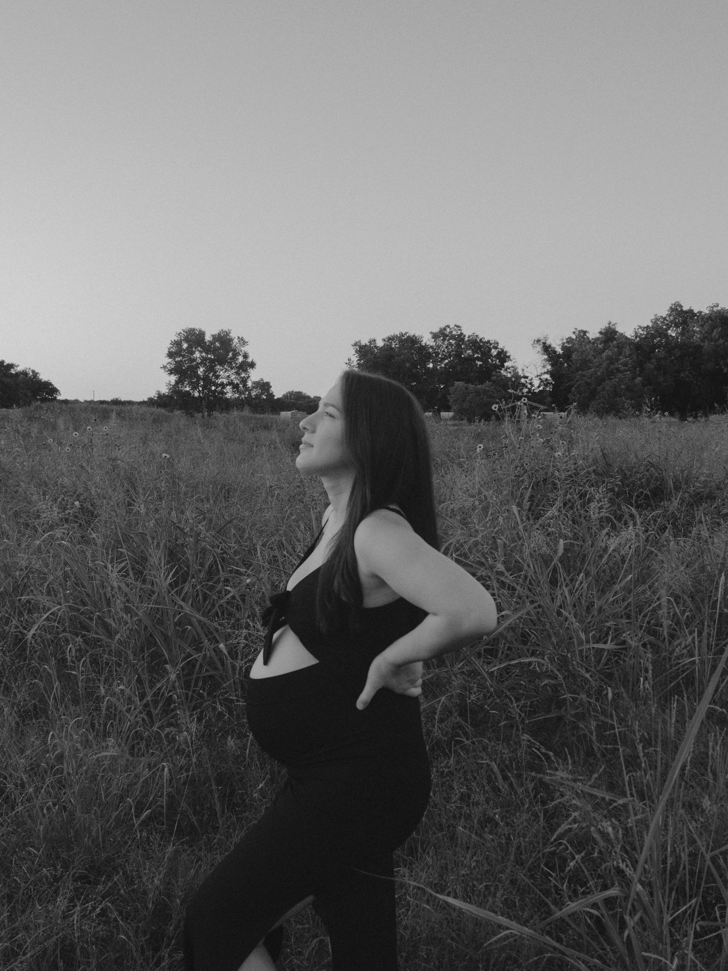 A series of black and white photos show a figure in dark clothing standing against a wild grass field.