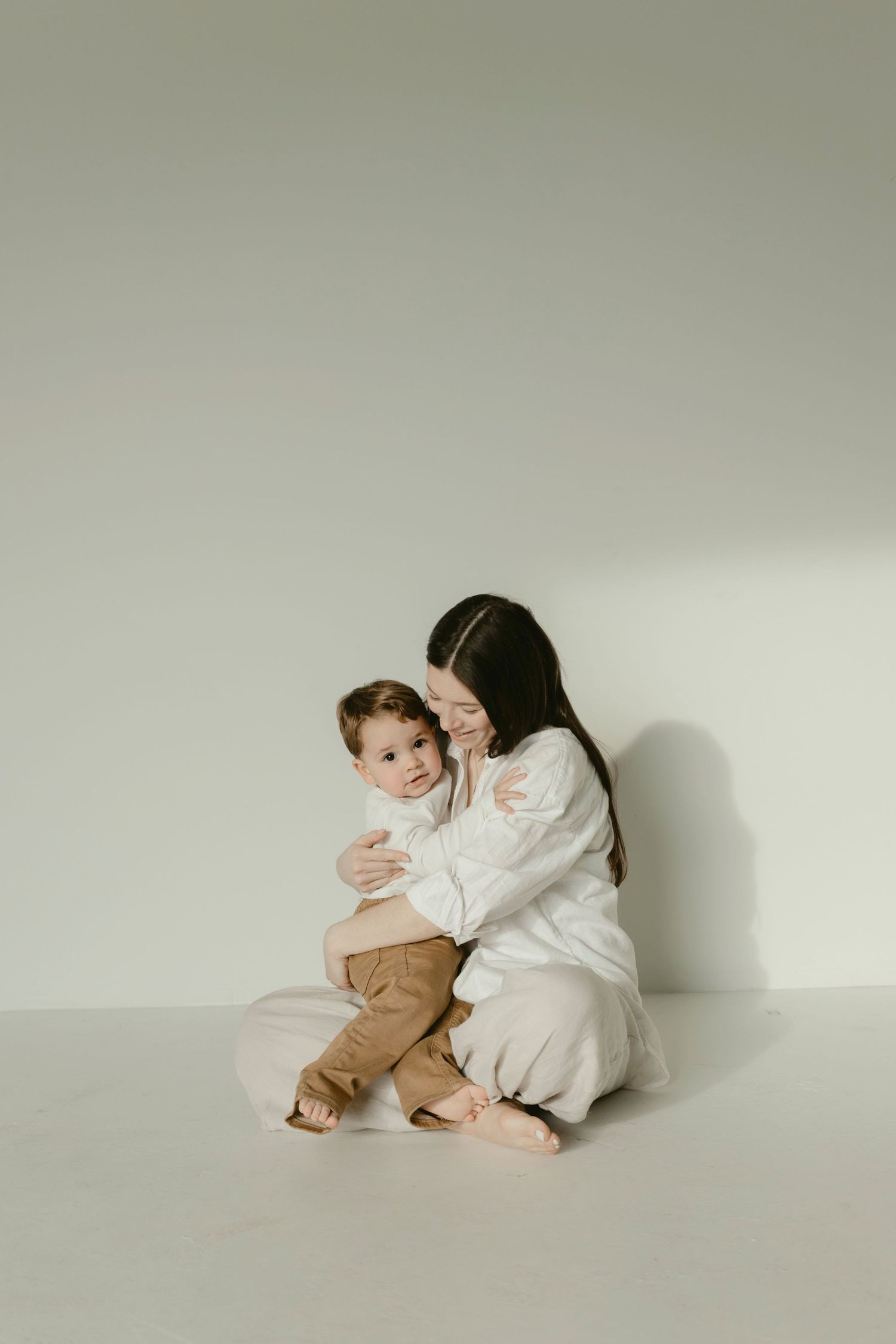 A mom sitting down and holding her toddler