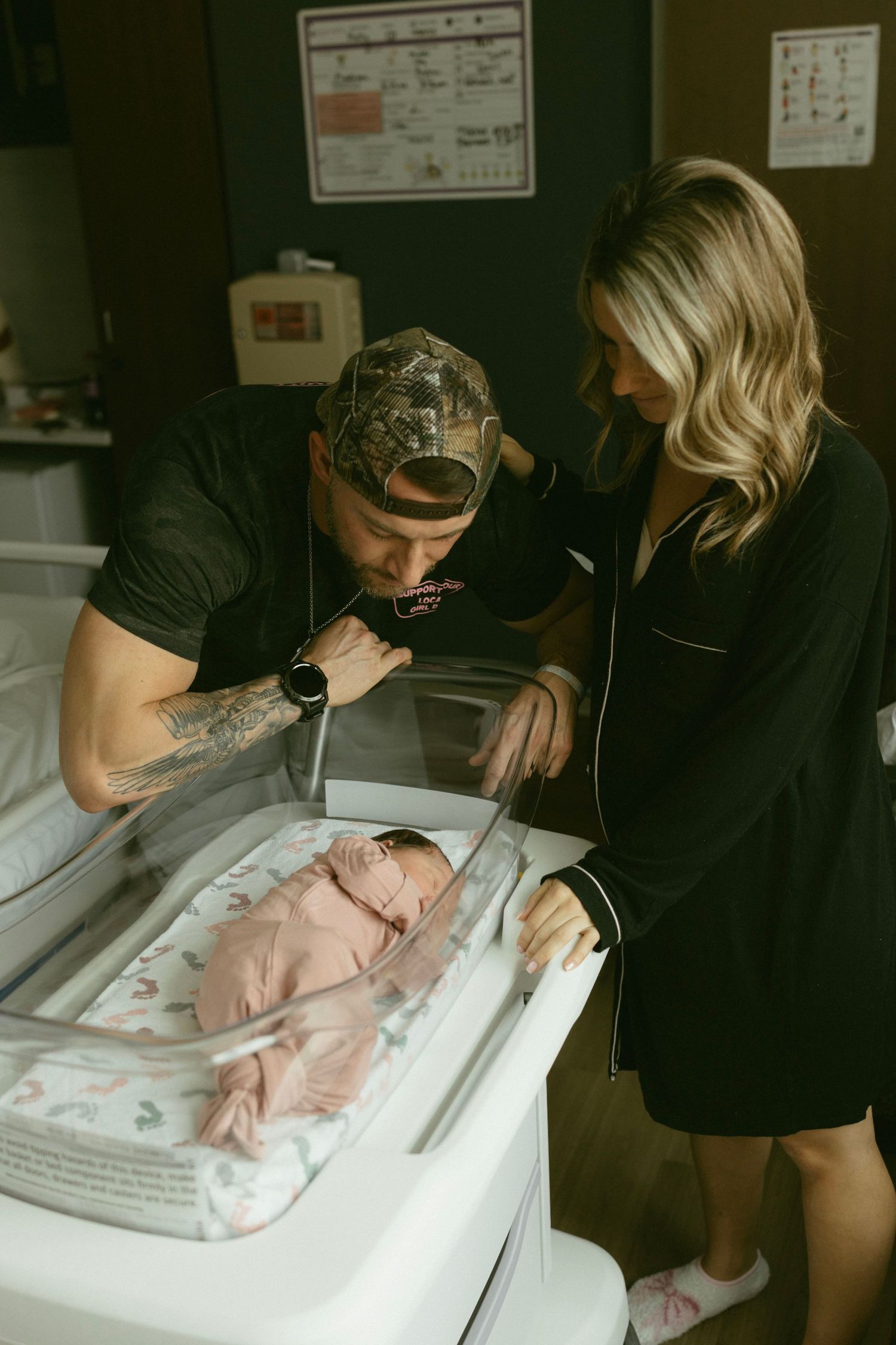 A mom and dad admiring their newborn in the hospital