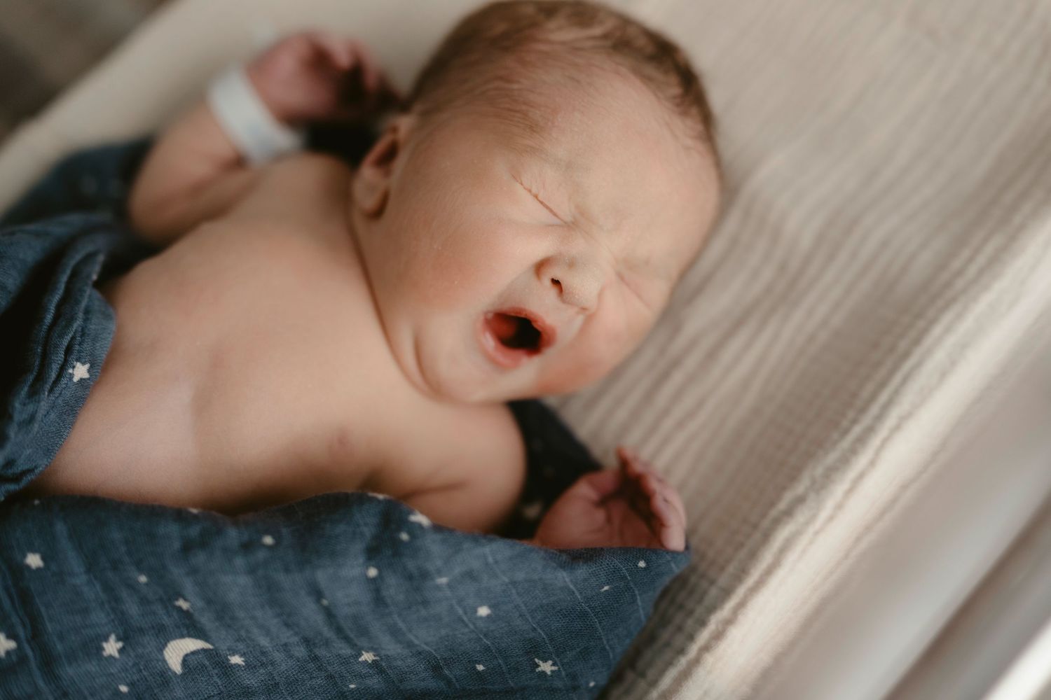 A sleeping baby lies peacefully on white bedding in a series of connected photos showing different angles.