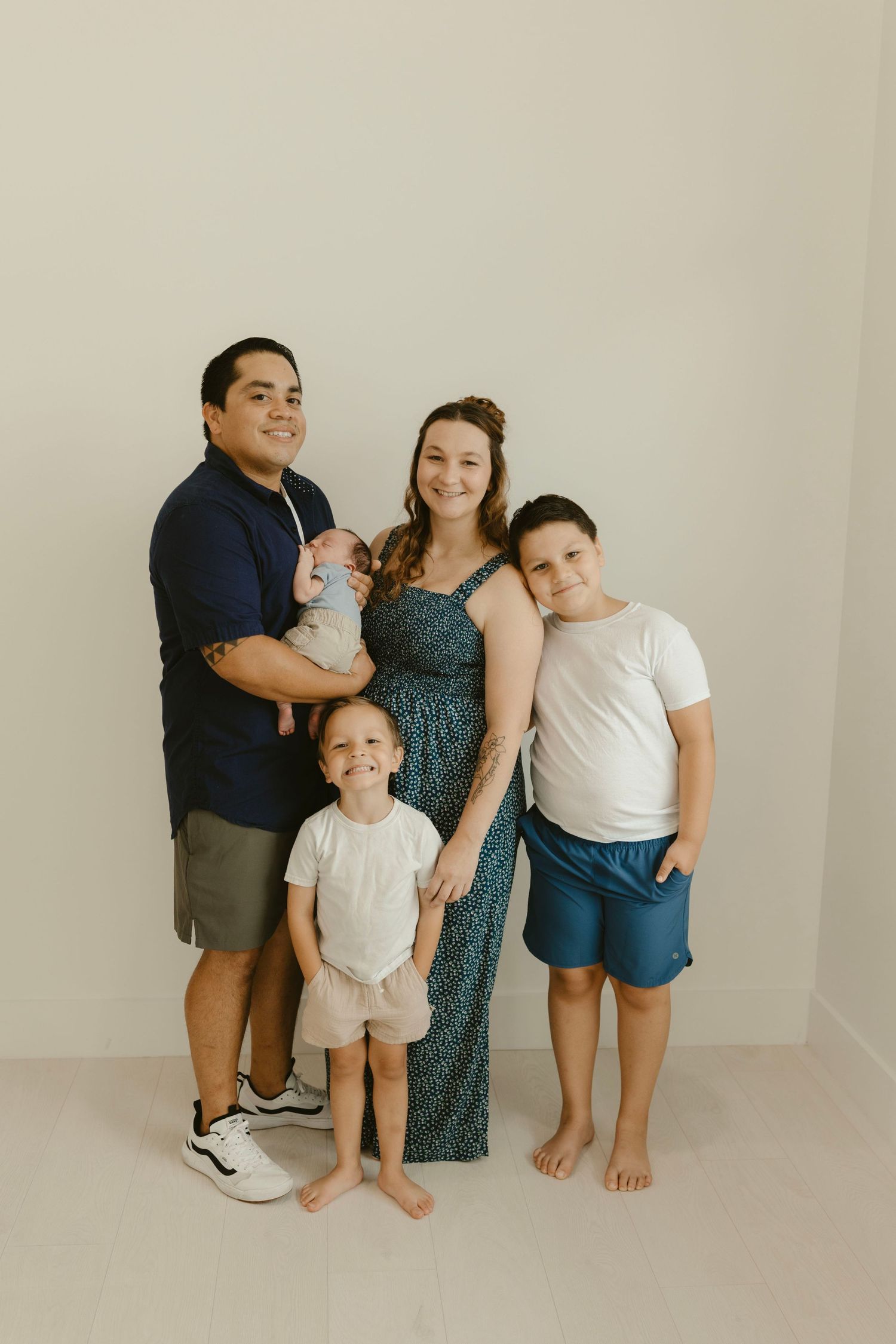 Photographer, Brittany Ruiz, based in Georgetown, TX, & surrounding areas, poses with her family of 5 in a studio family portrait.