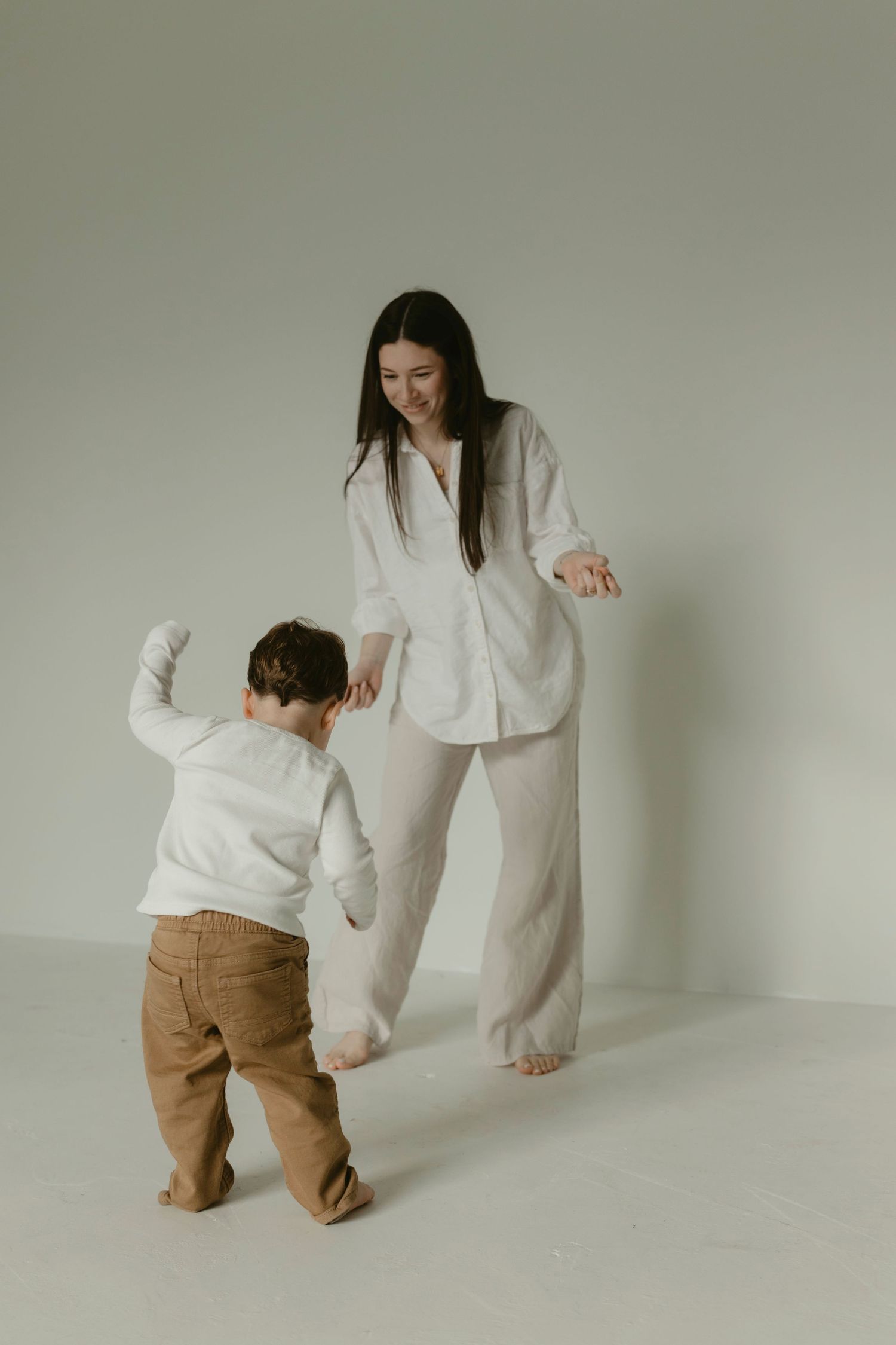 A mom and her son dancing together during a minimalist motherhood studio session in Central Texas.