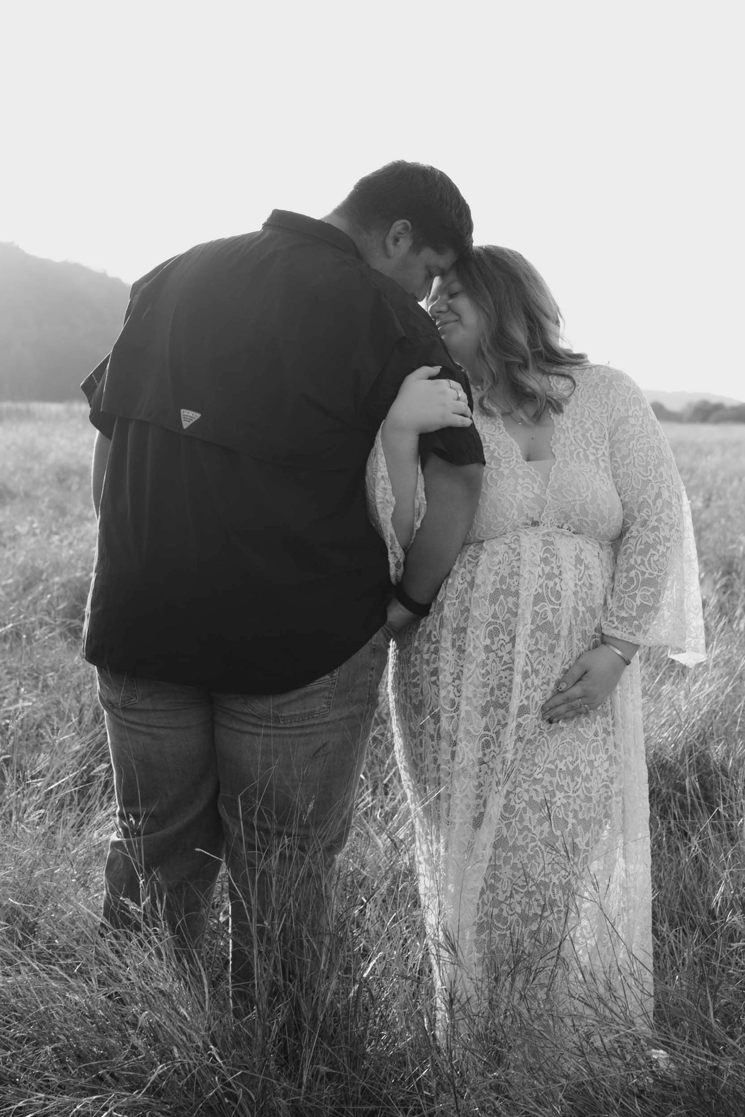 A romantic black and white photo sequence shows a couple embracing in a tall grass field at sunset.