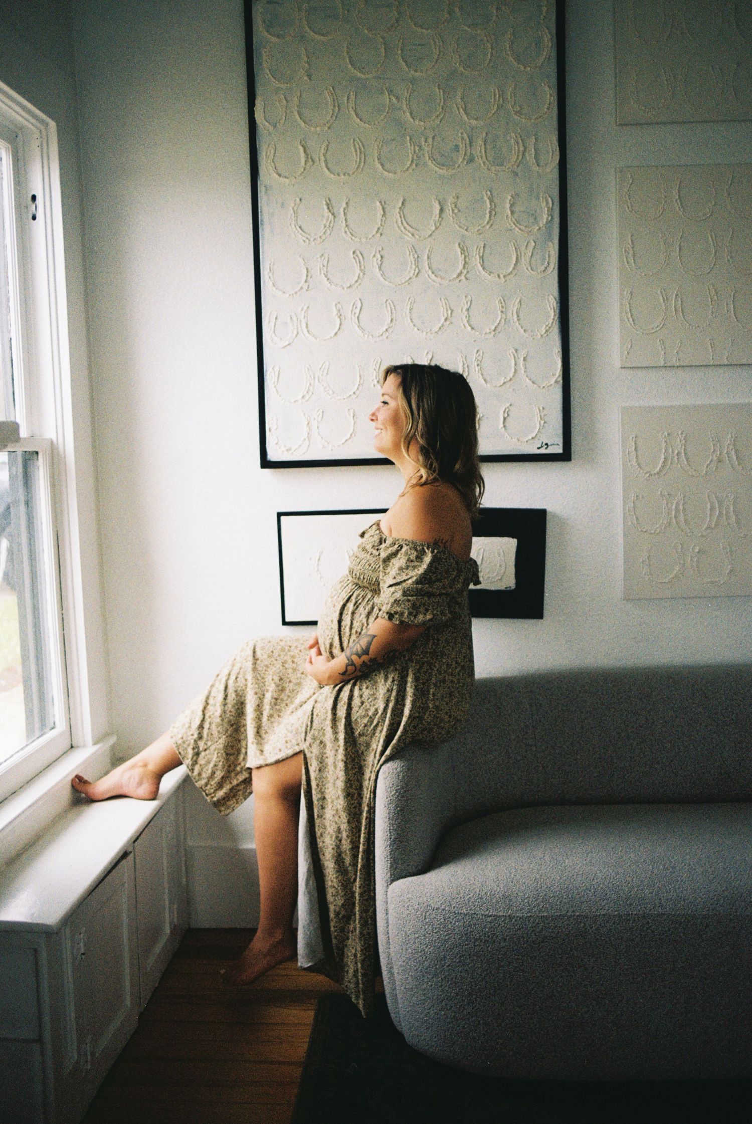 Artistic window light portraits in moody interior with circular wall art.