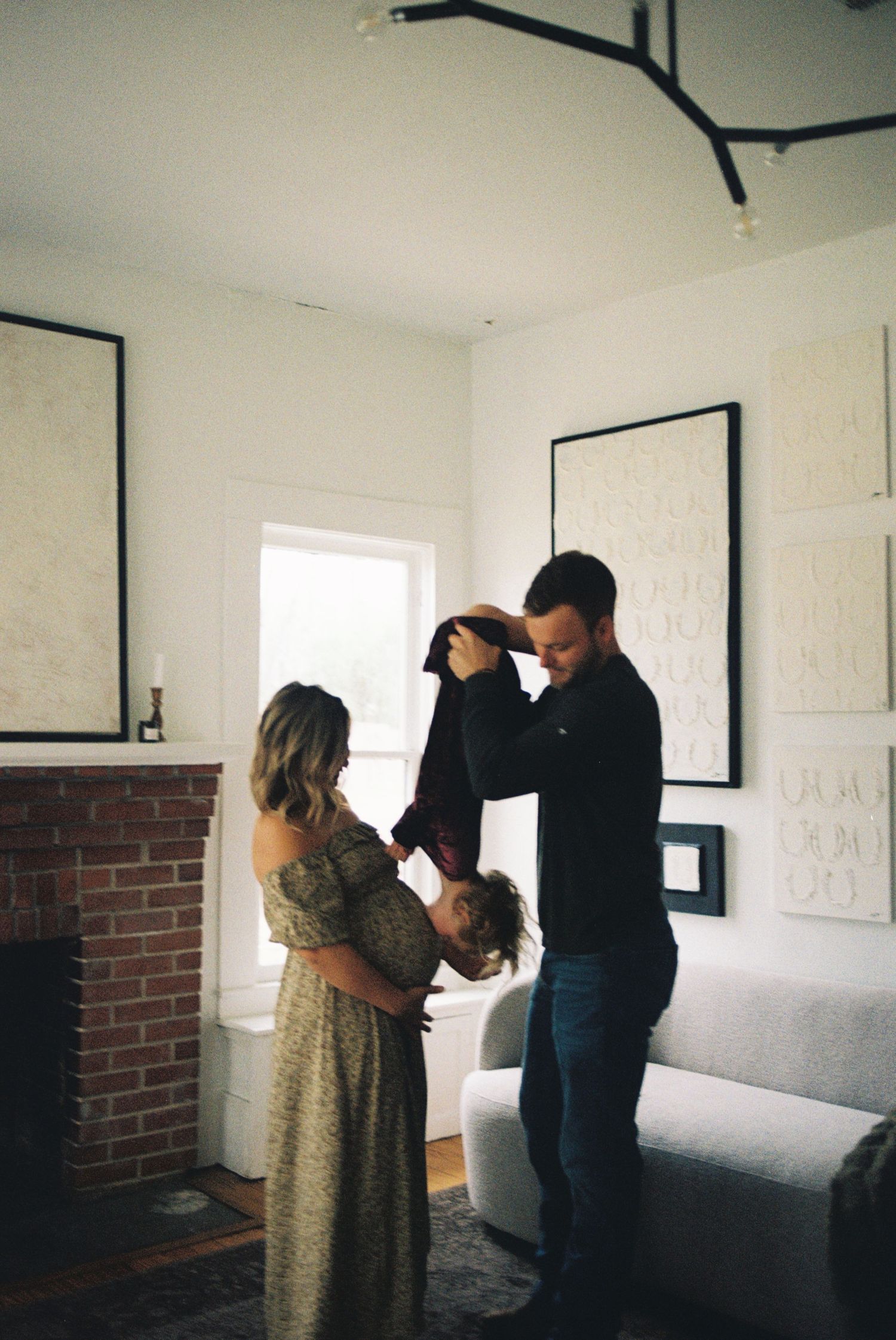 A sequence of photos showing two people in a white room with artwork on walls examining or installing pieces.