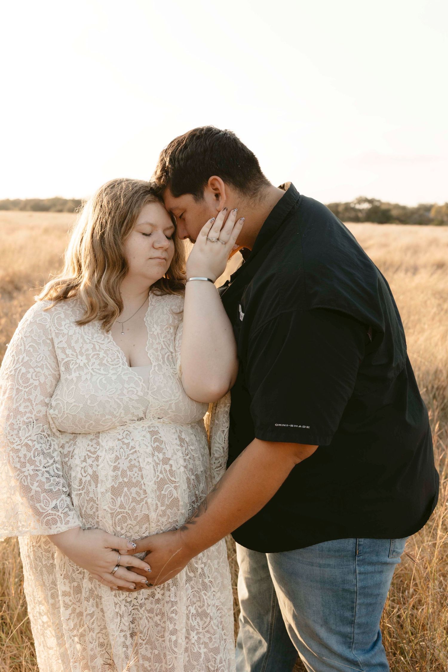 A romantic couple shares intimate moments in a golden wheat field during sunset.
