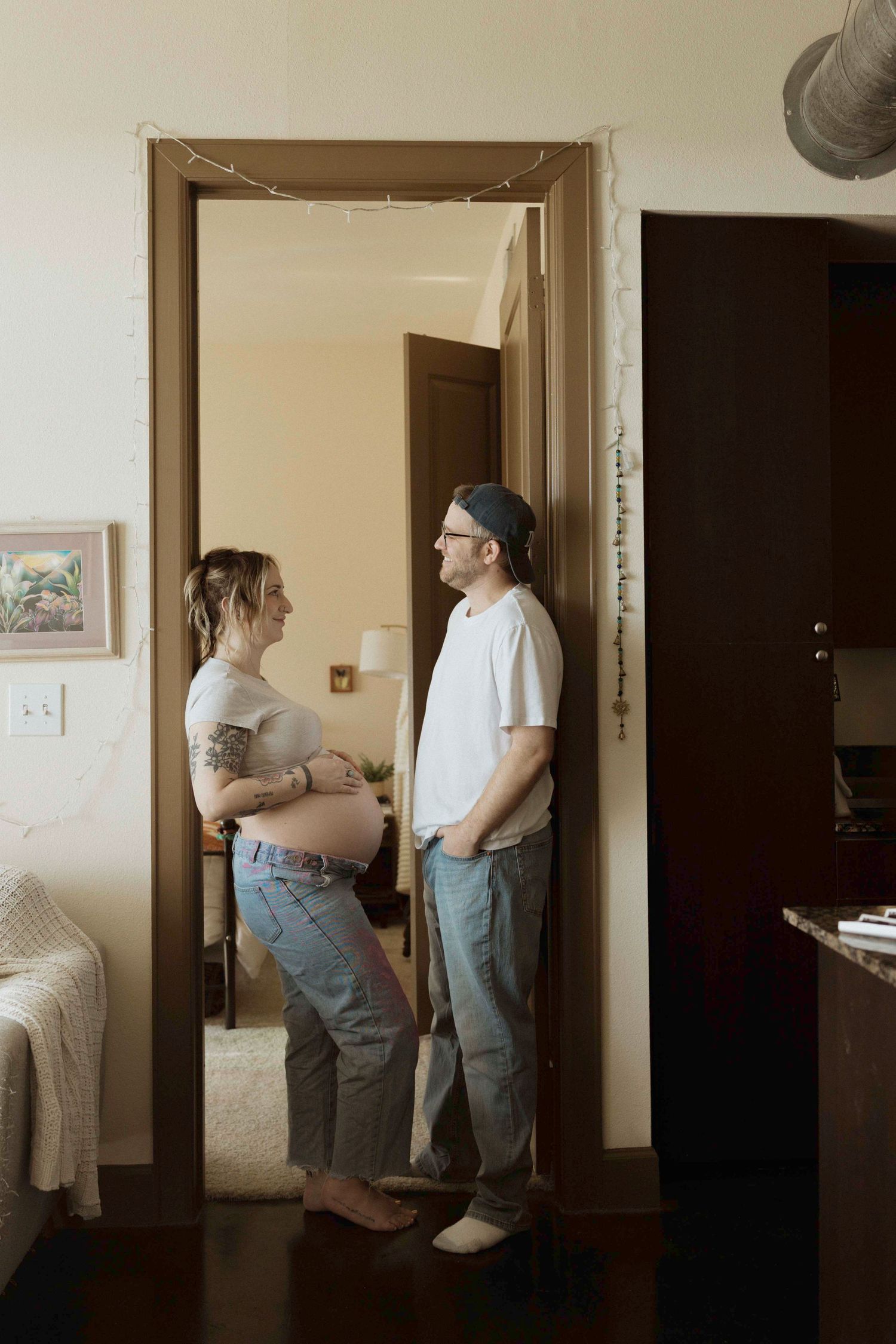 Series of candid indoor moments showing connection between an expectant mother and dad.