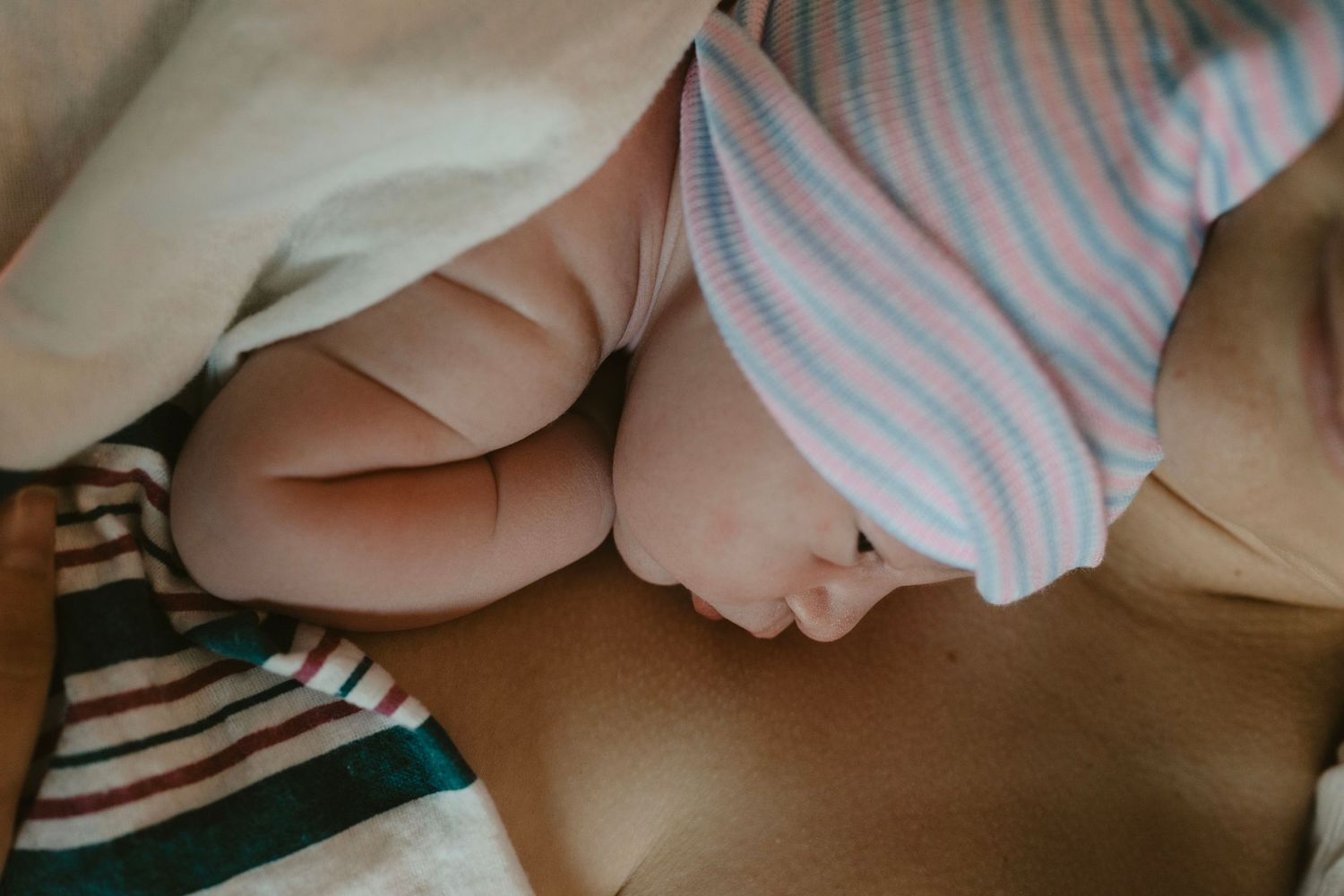 Birth photography capturing a quiet skin-to-skin moment between a mother and her baby.