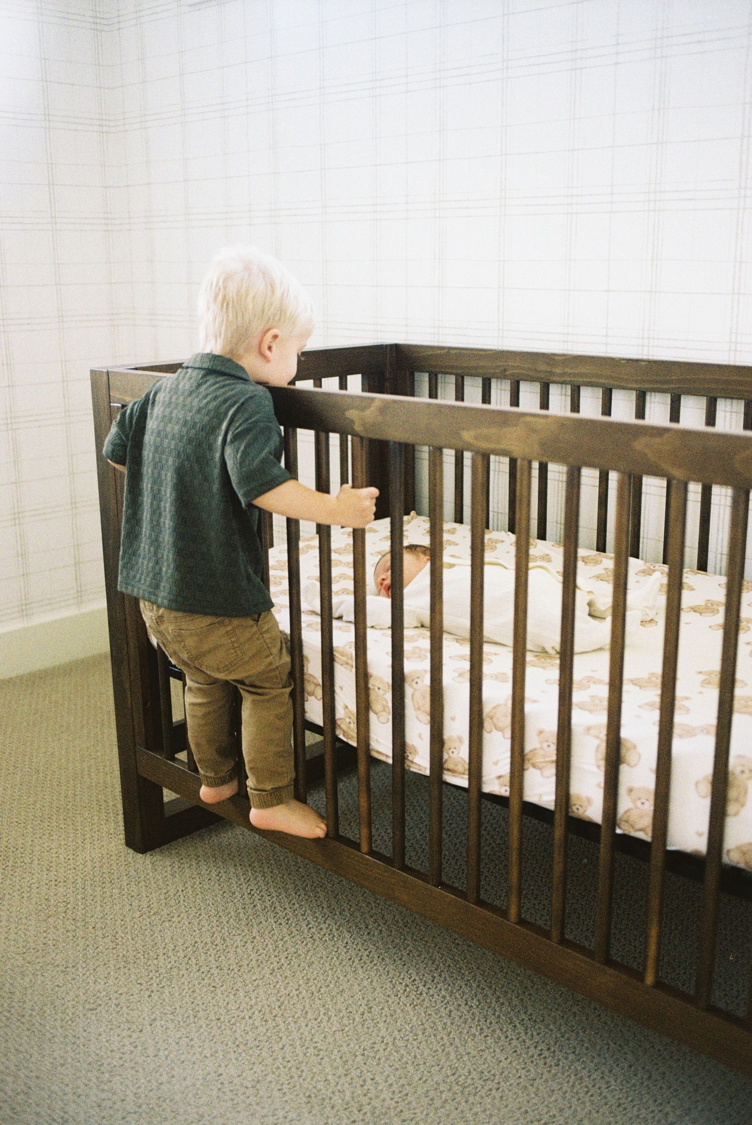 A sequence of photos showing a person in green sweater peering into a wooden crib from different angles.