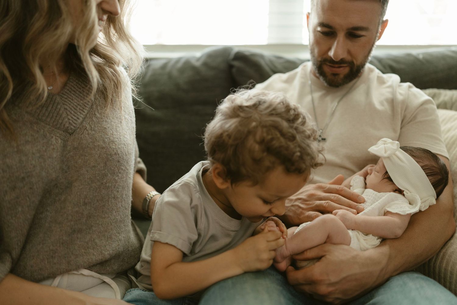 A series of tender family moments showing parents bonding with their newborn baby on a couch at home.