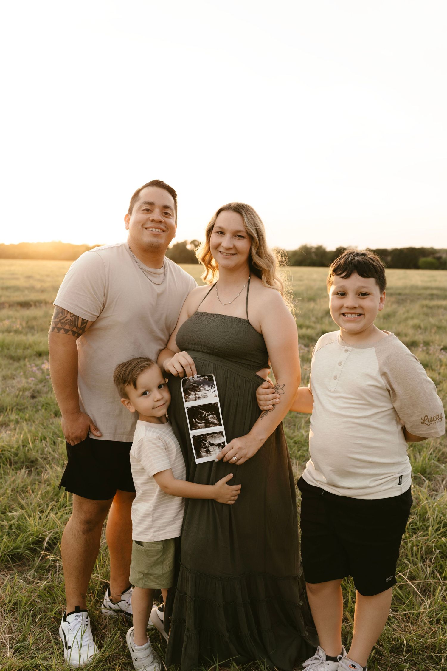 Photographer, Brittany Ruiz, based in Georgetown, TX, & surrounding areas, poses with family outdoors for pregnancy announcement photos.