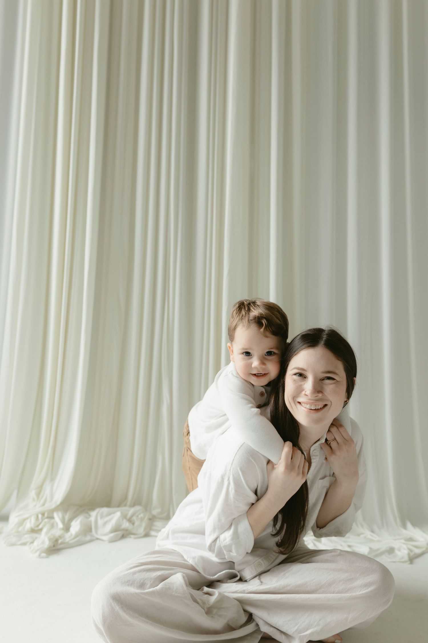 Three connected photos show two people lying together under white sheets against a light curtain backdrop.