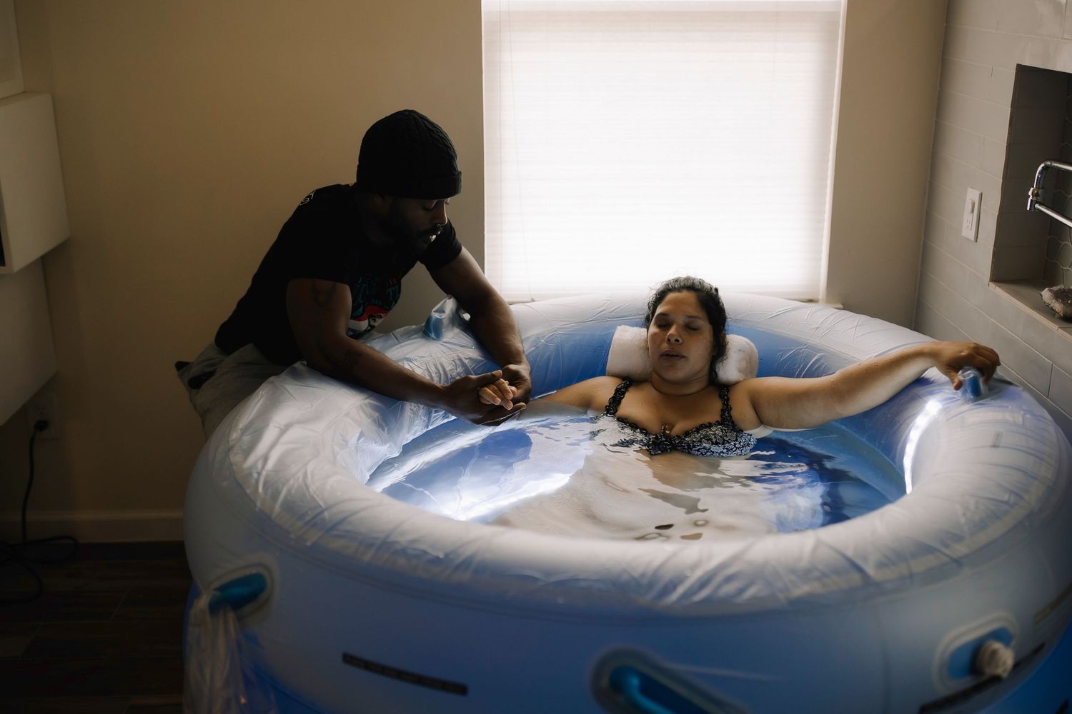 Natural birth photography capturing a mother experiencing contractions during a water birth.