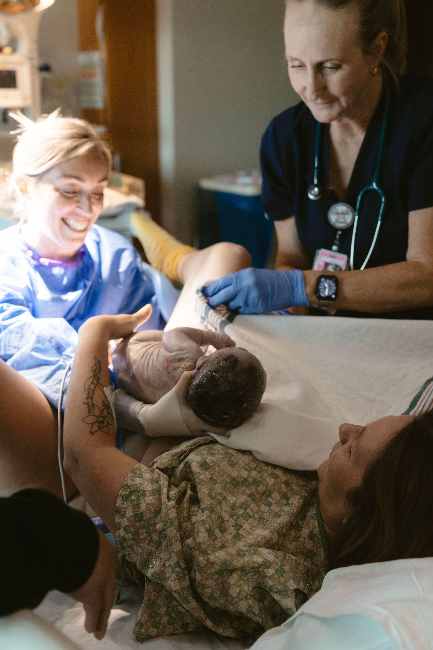 Documentary-style birth photo showing a mother during the powerful moments of delivery.