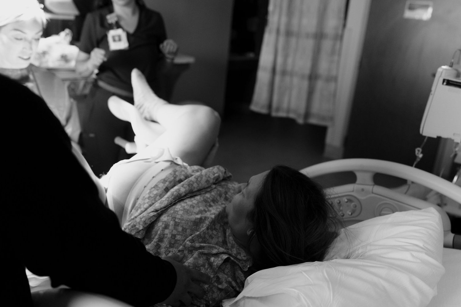 Documentary birth photo capturing a mother during active labor moments before meeting her baby.