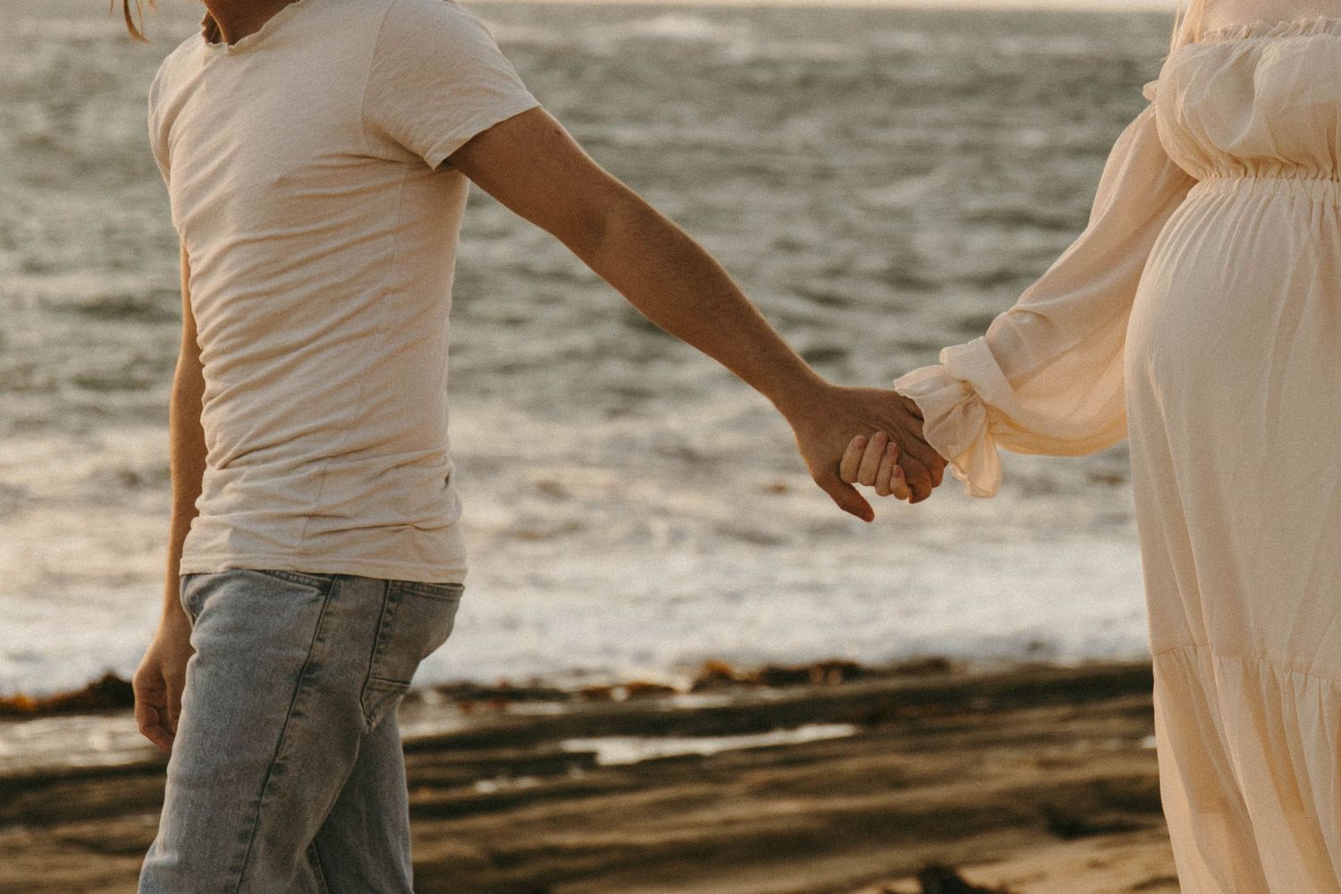 Dramatic, film-esque hand hold between partner and pregnant woman.