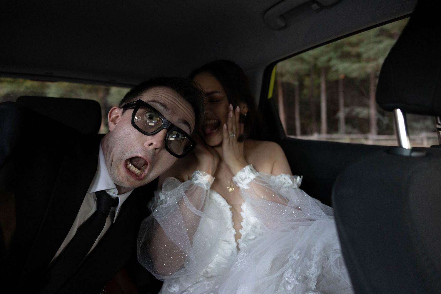 Bride and groom share a playful moment in a car, groom making a funny face wearing glasses. Wedding Photographer Santa Cruz CA. Elopements.