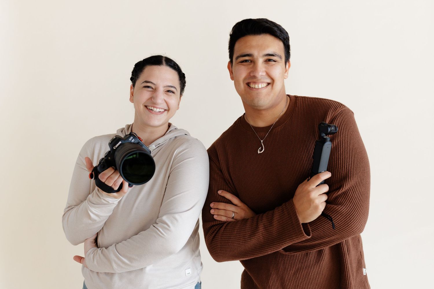 team photo of photography team, showing female photographer holding Canon R6 mirrorless camera, and Male videographer holding the osmo 3.